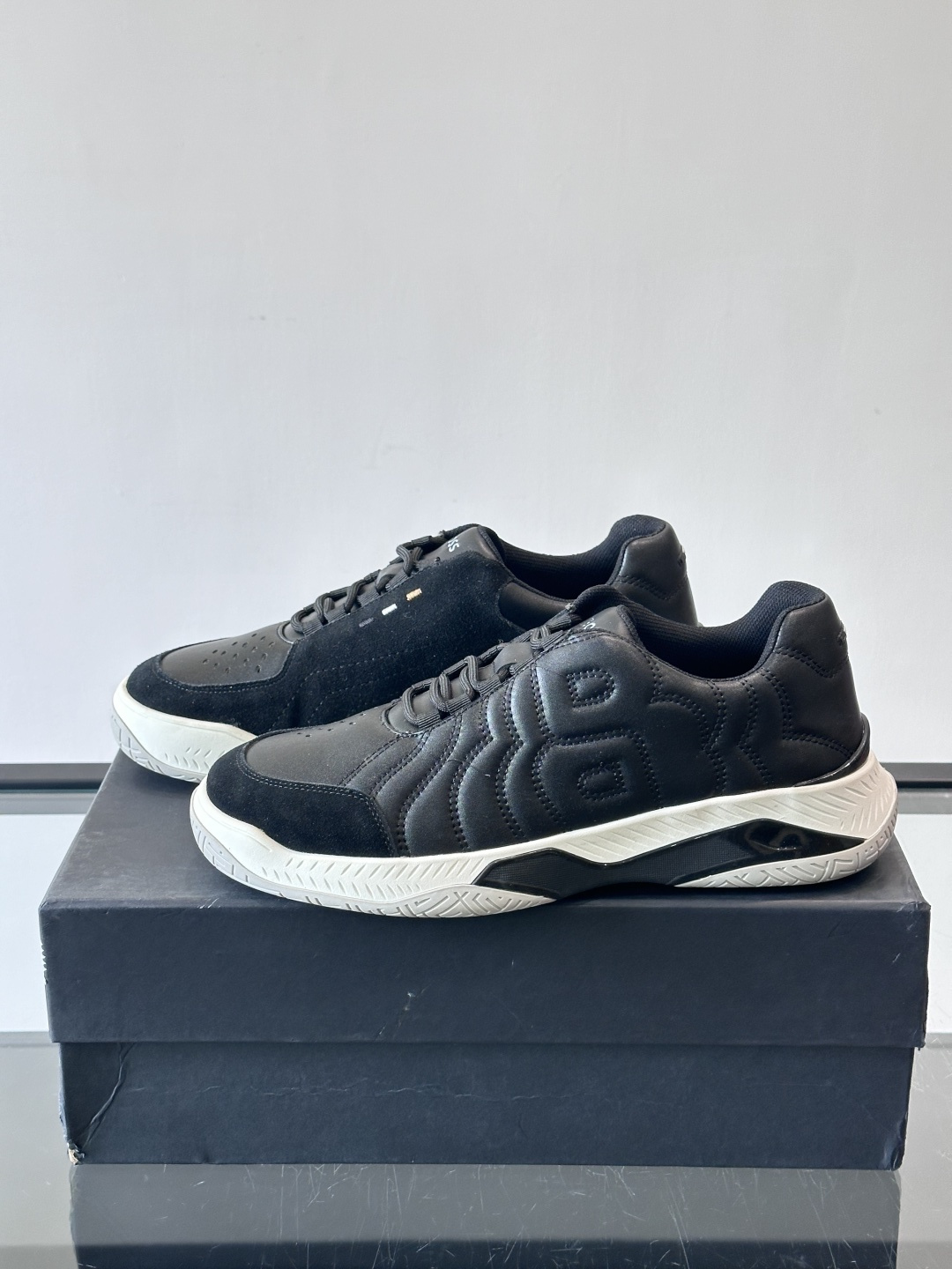 Boss Courtstride系列休闲鞋，灵感来自网球鞋，鞋面采用牛皮+绒面革拼接，绗缝工艺+双B标志