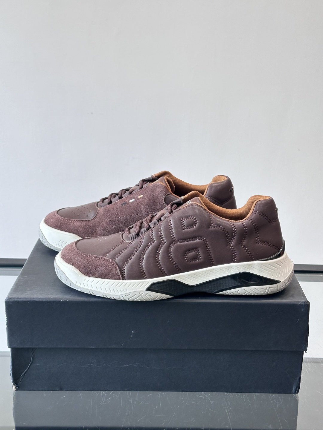 Boss Courtstride系列休闲鞋，灵感来自网球鞋，鞋面采用牛皮+绒面革拼接，绗缝工艺+双B标志