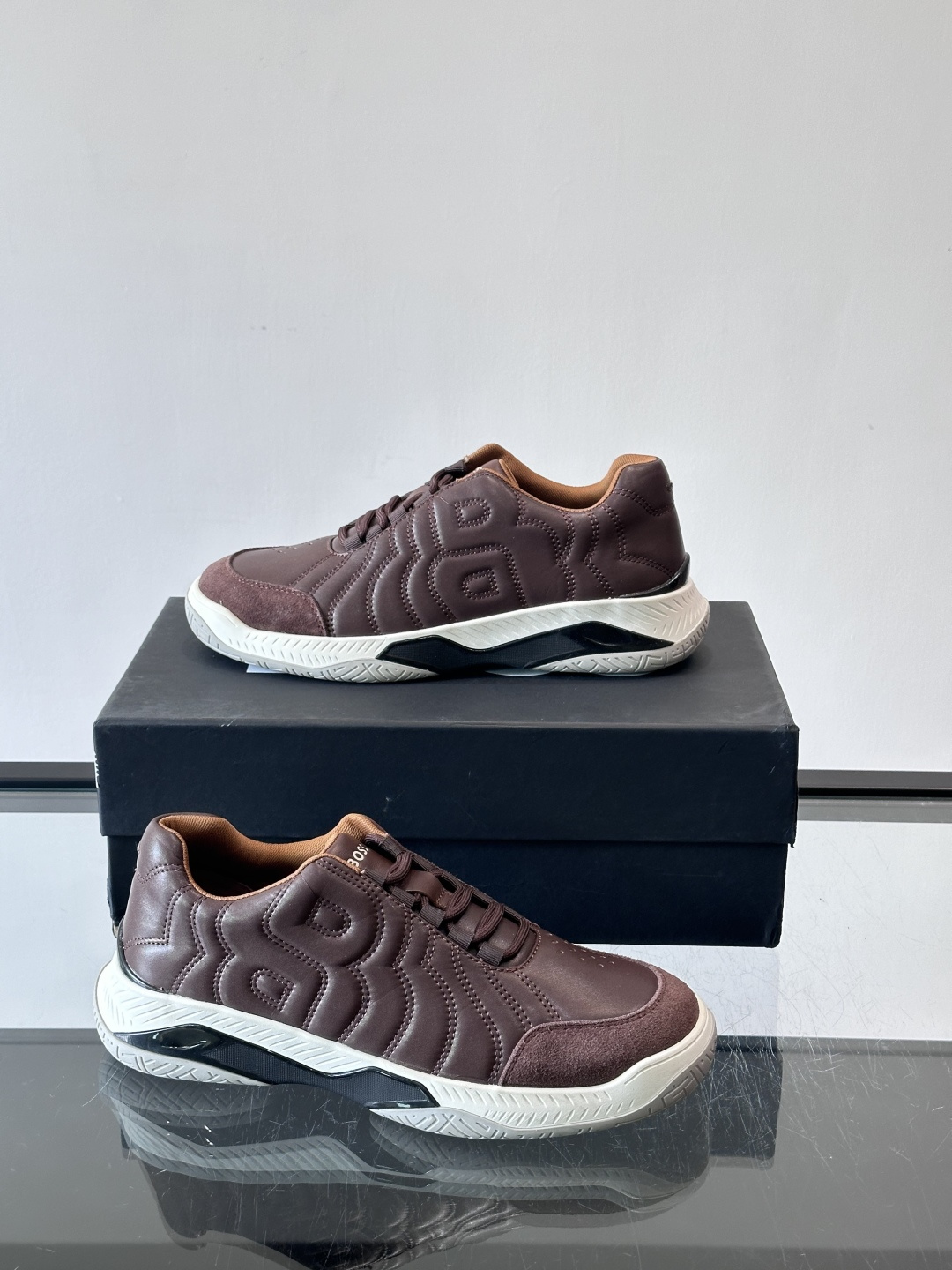 Boss Courtstride系列休闲鞋，灵感来自网球鞋，鞋面采用牛皮+绒面革拼接，绗缝工艺+双B标志