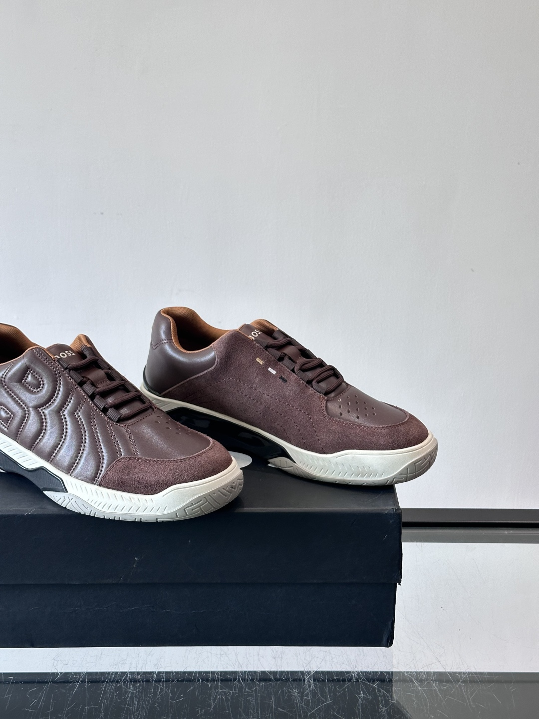 Boss Courtstride系列休闲鞋，灵感来自网球鞋，鞋面采用牛皮+绒面革拼接，绗缝工艺+双B标志