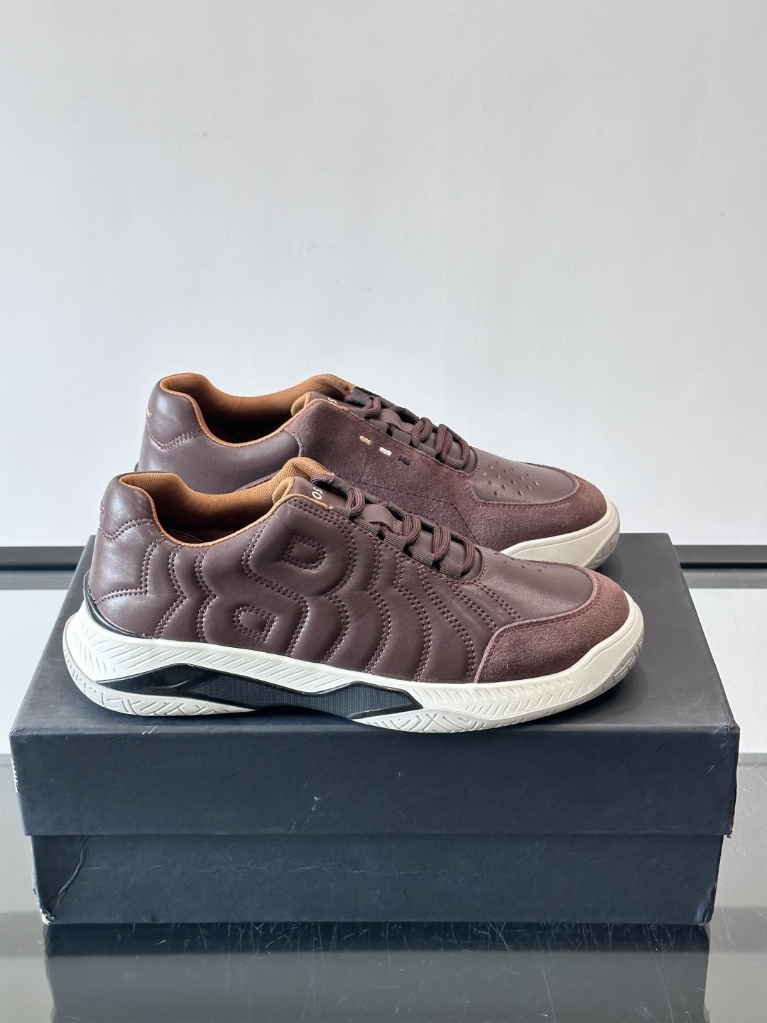 Boss Courtstride系列休闲鞋，灵感来自网球鞋，鞋面采用牛皮+绒面革拼接，绗缝工艺+双B标志