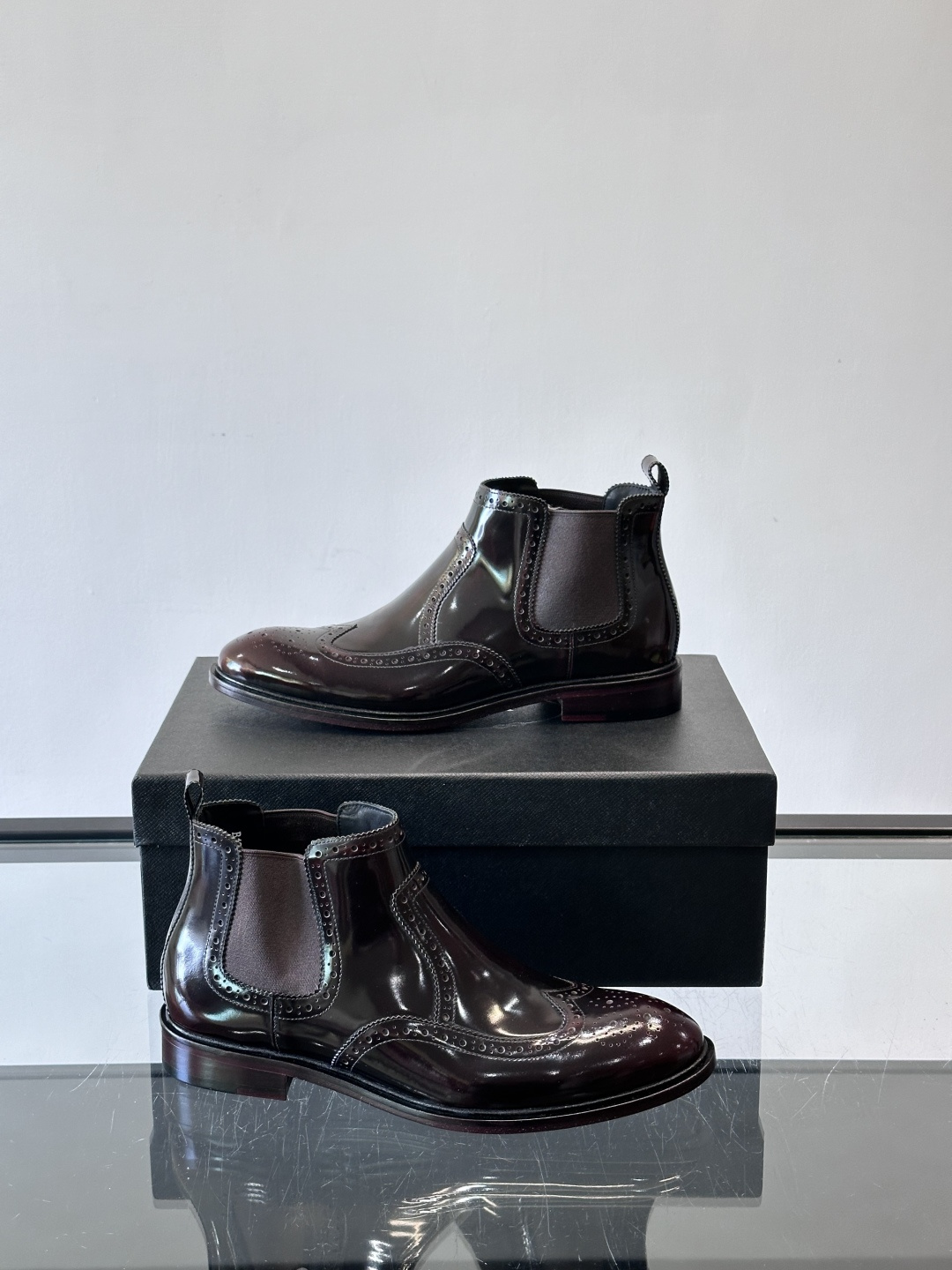 Prada普拉达布洛克雕花切尔西靴，英伦风代表，采用高光抛光皮革，光泽感如黑曜石。鞋面布洛克雕花，细节精