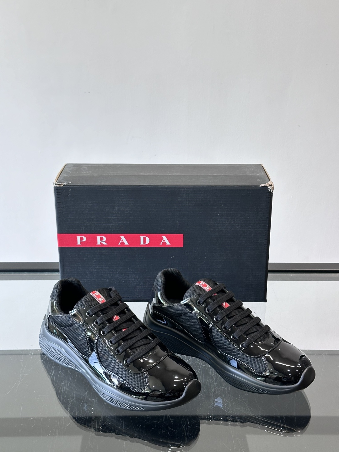 Prada 美洲杯运动鞋​​✨Prada美洲杯系列运动鞋，漆皮+网面拼接，光泽感与透气性兼具。低帮设计，