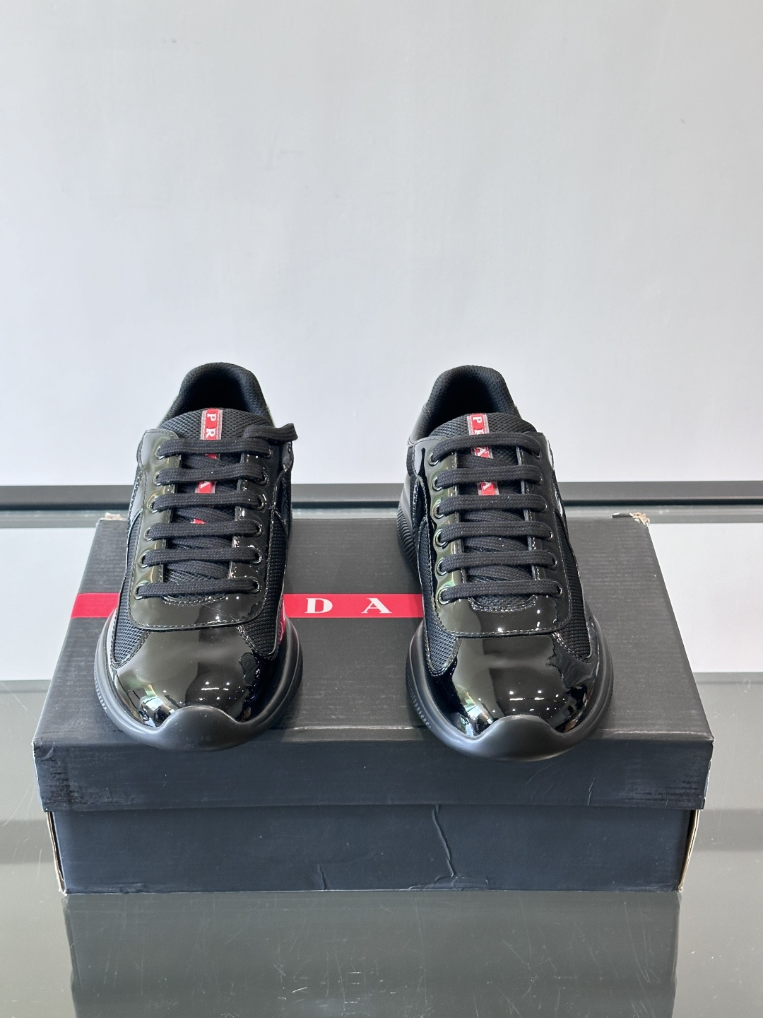 Prada 美洲杯运动鞋​​✨Prada美洲杯系列运动鞋，漆皮+网面拼接，光泽感与透气性兼具。低帮设计，