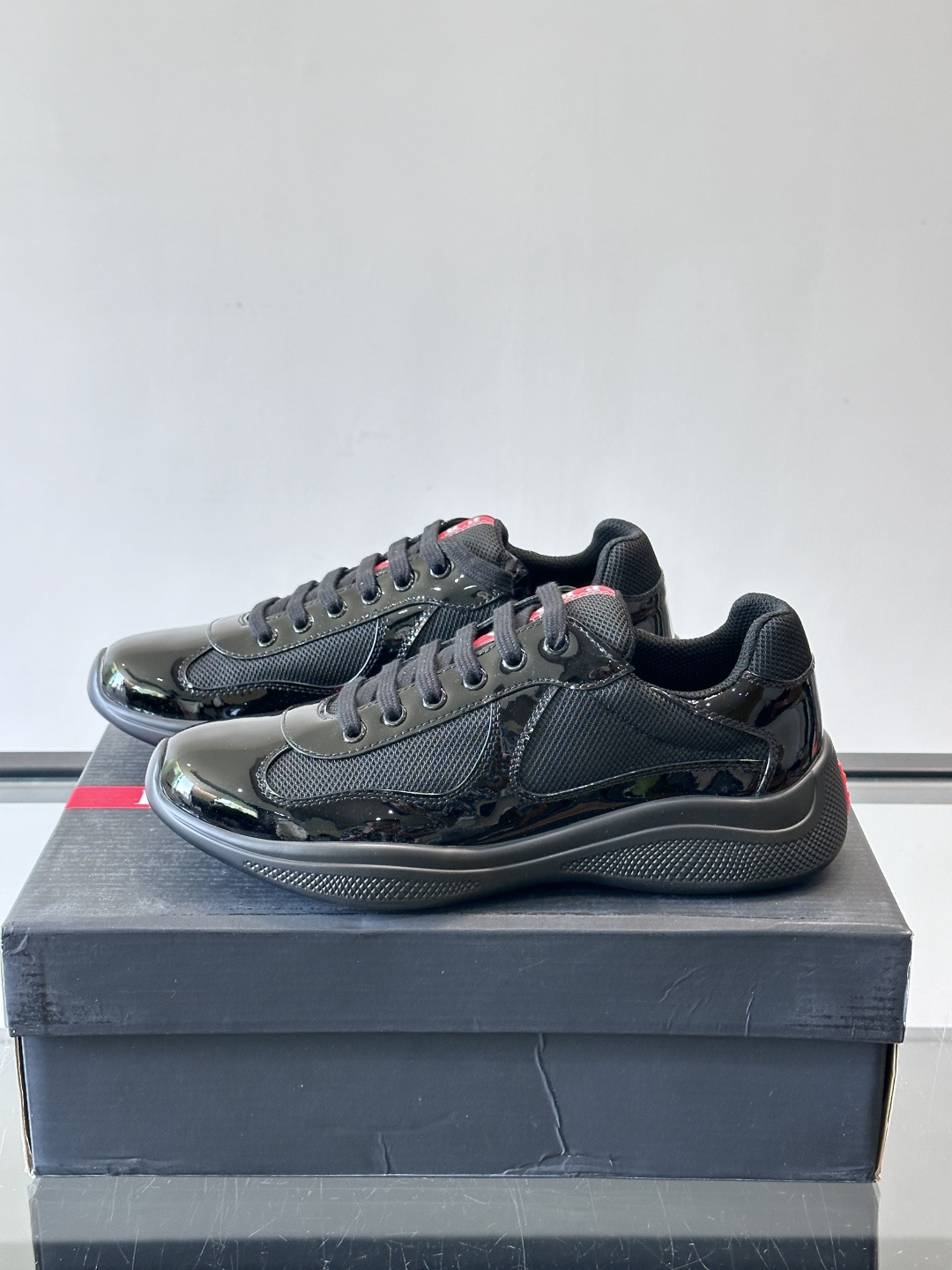 Prada 美洲杯运动鞋​​✨Prada美洲杯系列运动鞋，漆皮+网面拼接，光泽感与透气性兼具。低帮设计，