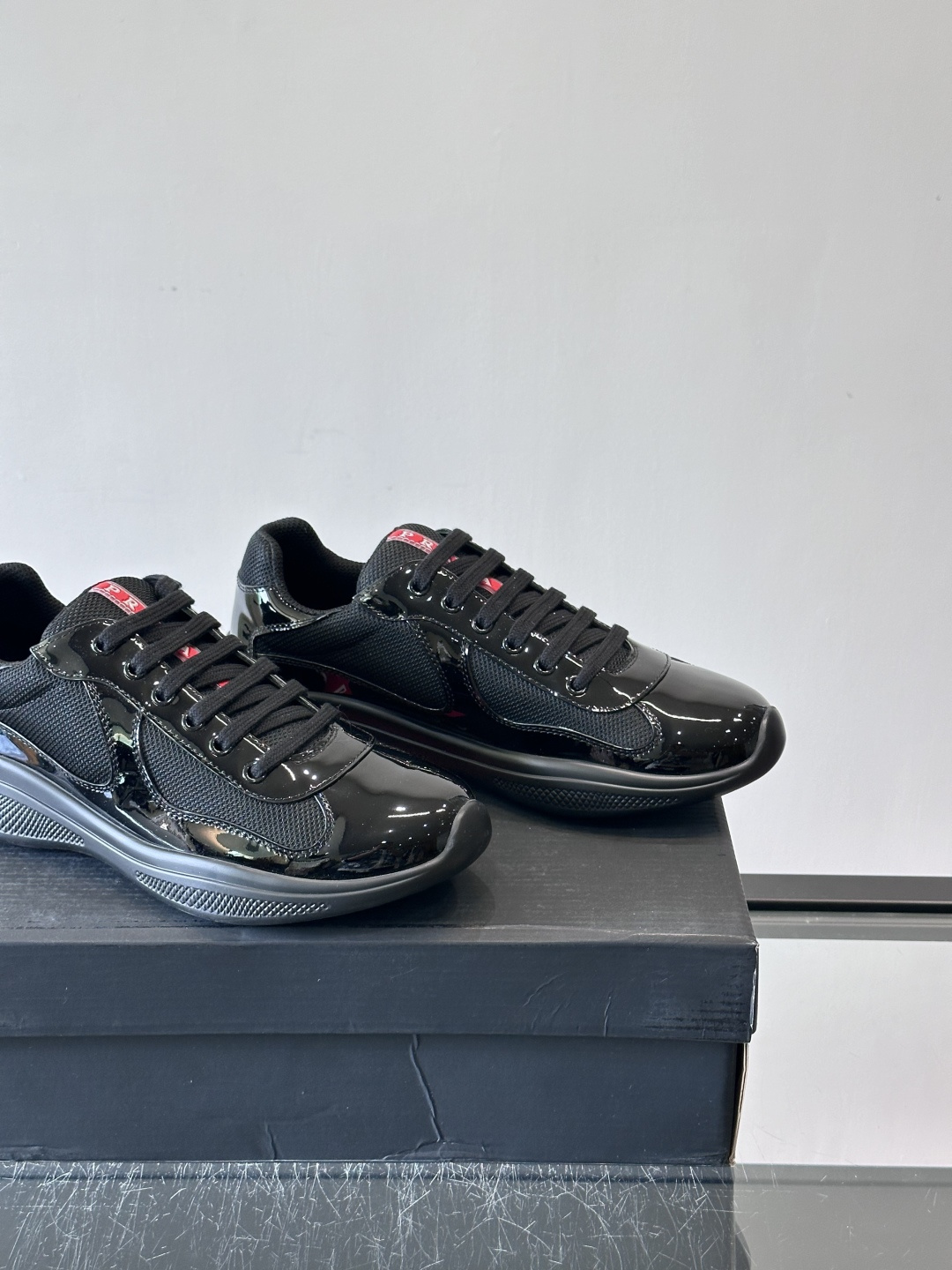 Prada 美洲杯运动鞋​​✨Prada美洲杯系列运动鞋，漆皮+网面拼接，光泽感与透气性兼具。低帮设计，