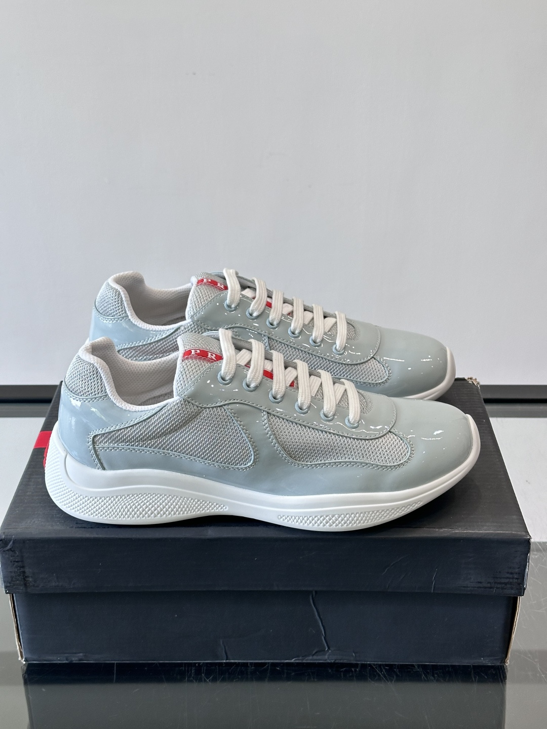 Prada 美洲杯运动鞋​​✨Prada美洲杯系列运动鞋，漆皮+网面拼接，光泽感与透气性兼具。低帮设计，