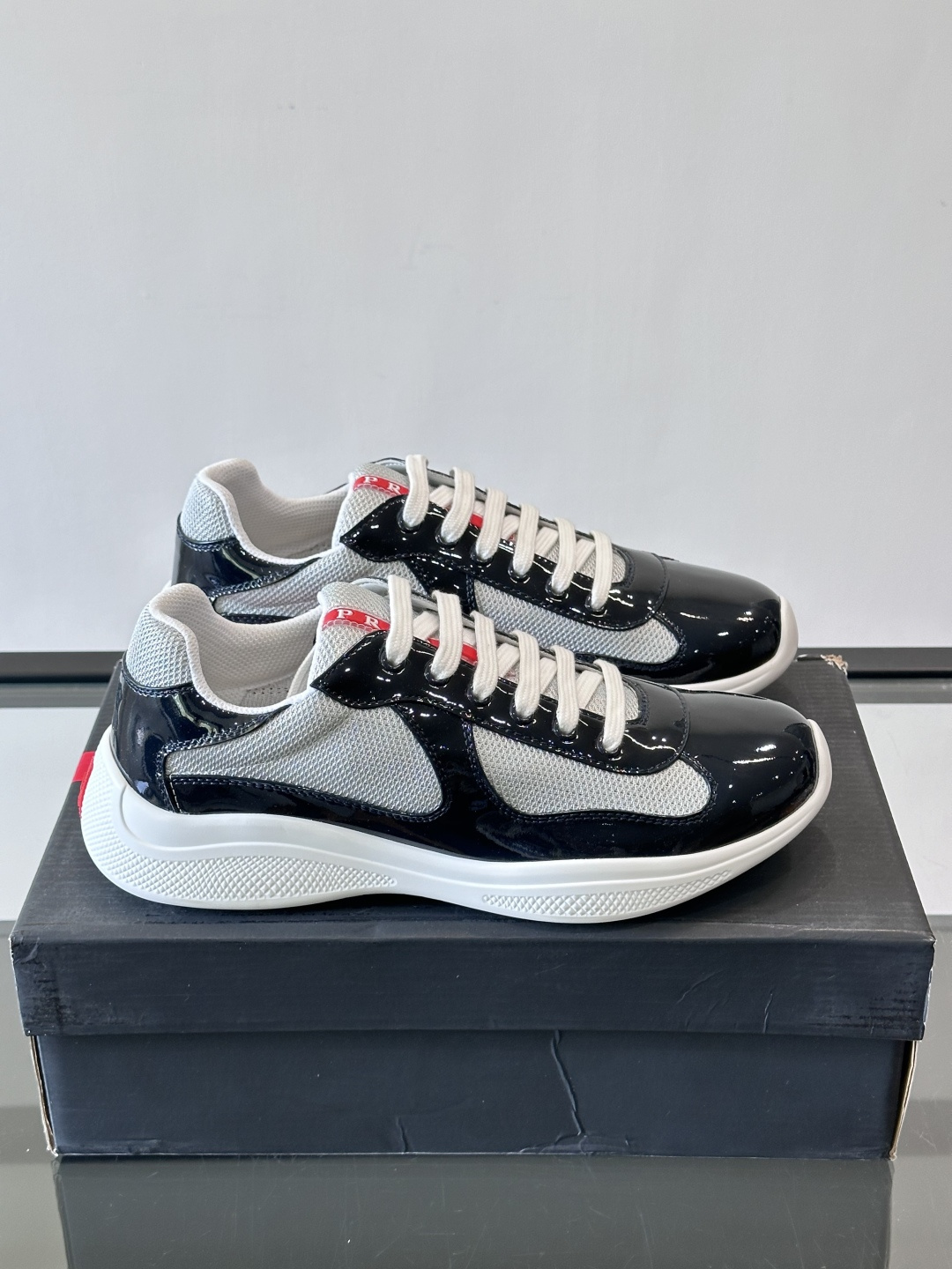 Prada 美洲杯运动鞋​​✨Prada美洲杯系列运动鞋，漆皮+网面拼接，光泽感与透气性兼具。低帮设计，