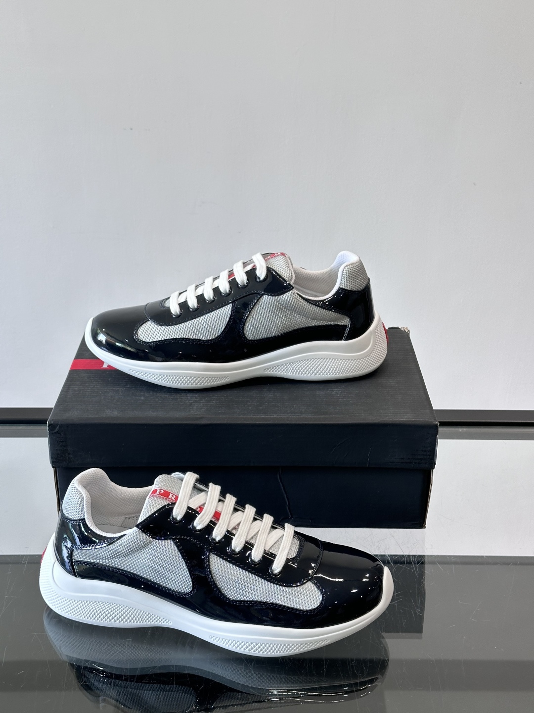 Prada 美洲杯运动鞋​​✨Prada美洲杯系列运动鞋，漆皮+网面拼接，光泽感与透气性兼具。低帮设计，