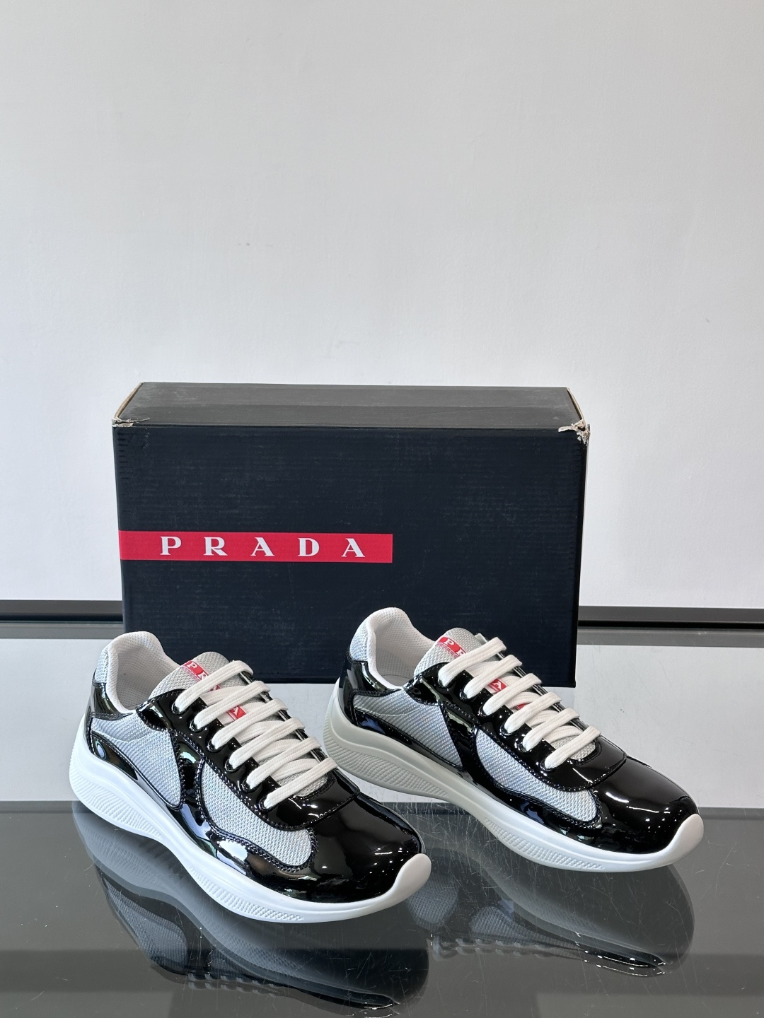 Prada 美洲杯运动鞋​​✨Prada美洲杯系列运动鞋，漆皮+网面拼接，光泽感与透气性兼具。低帮设计，