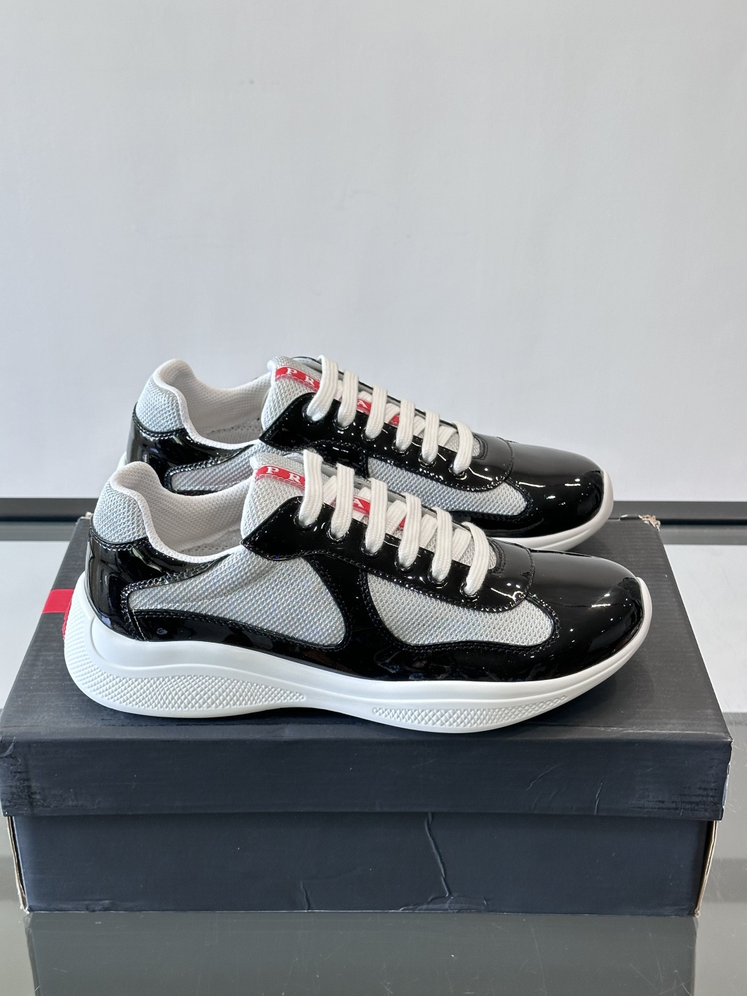 Prada 美洲杯运动鞋​​✨Prada美洲杯系列运动鞋，漆皮+网面拼接，光泽感与透气性兼具。低帮设计，