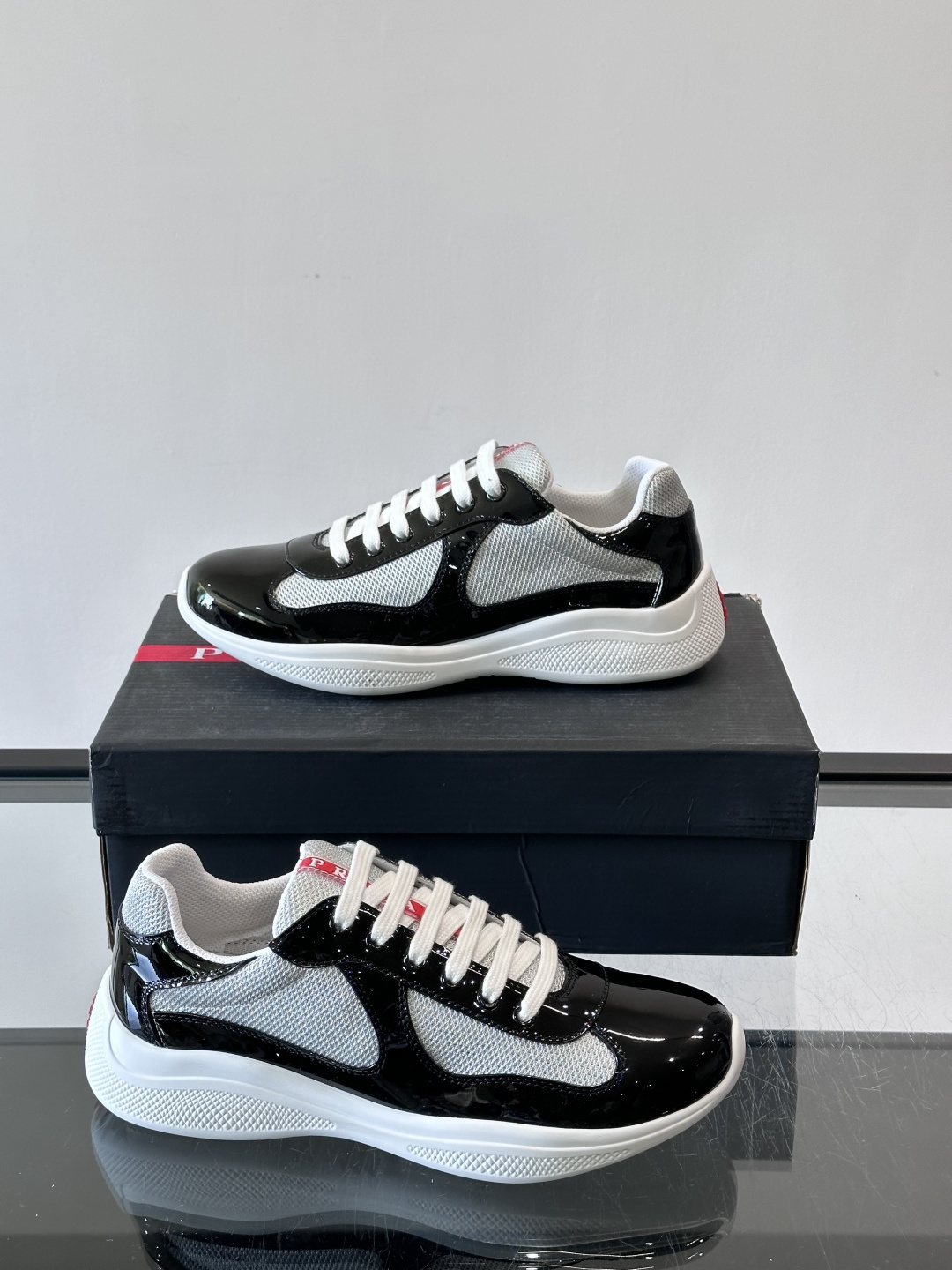 Prada 美洲杯运动鞋​​✨Prada美洲杯系列运动鞋，漆皮+网面拼接，光泽感与透气性兼具。低帮设计，