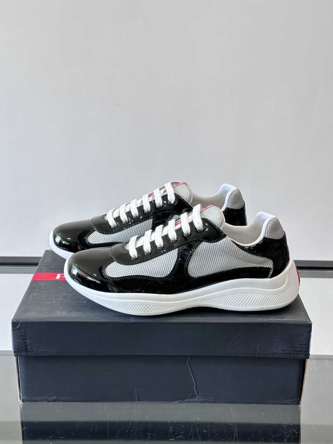 Prada 美洲杯运动鞋​​✨Prada美洲杯系列运动鞋，漆皮+网面拼接，光泽感与透气性兼具。低帮设计，