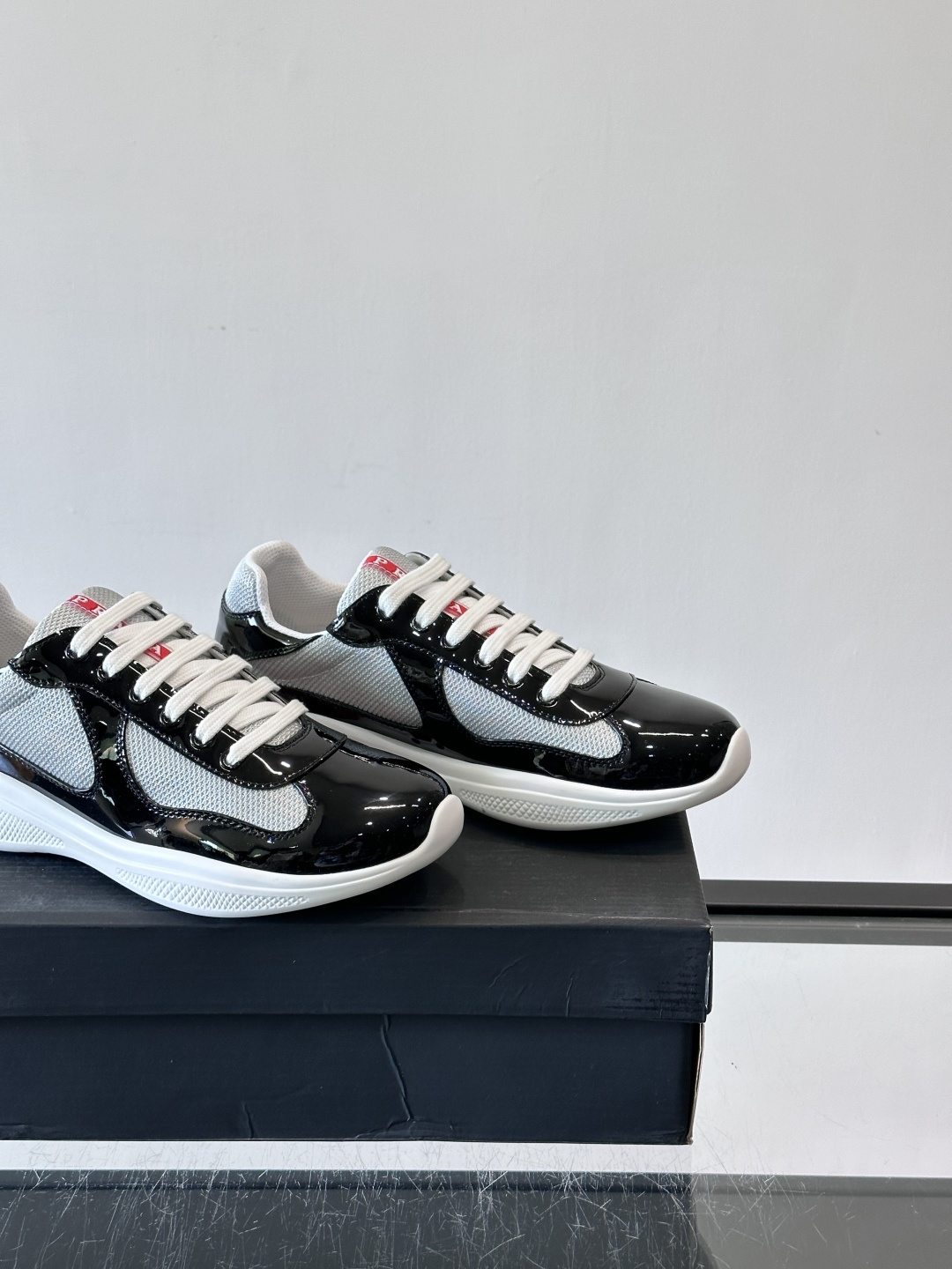 Prada 美洲杯运动鞋​​✨Prada美洲杯系列运动鞋，漆皮+网面拼接，光泽感与透气性兼具。低帮设计，