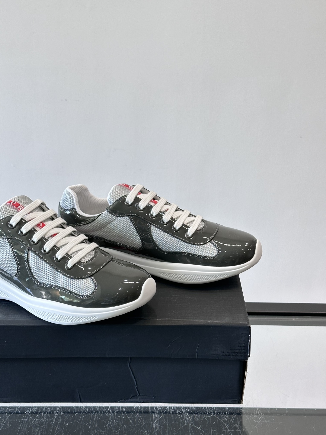 Prada 美洲杯运动鞋​​✨Prada美洲杯系列运动鞋，漆皮+网面拼接，光泽感与透气性兼具。低帮设计，