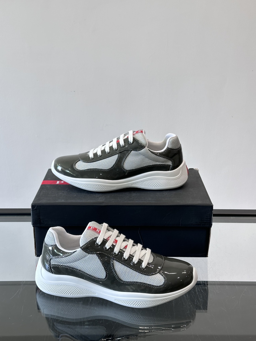 Prada 美洲杯运动鞋​​✨Prada美洲杯系列运动鞋，漆皮+网面拼接，光泽感与透气性兼具。低帮设计，
