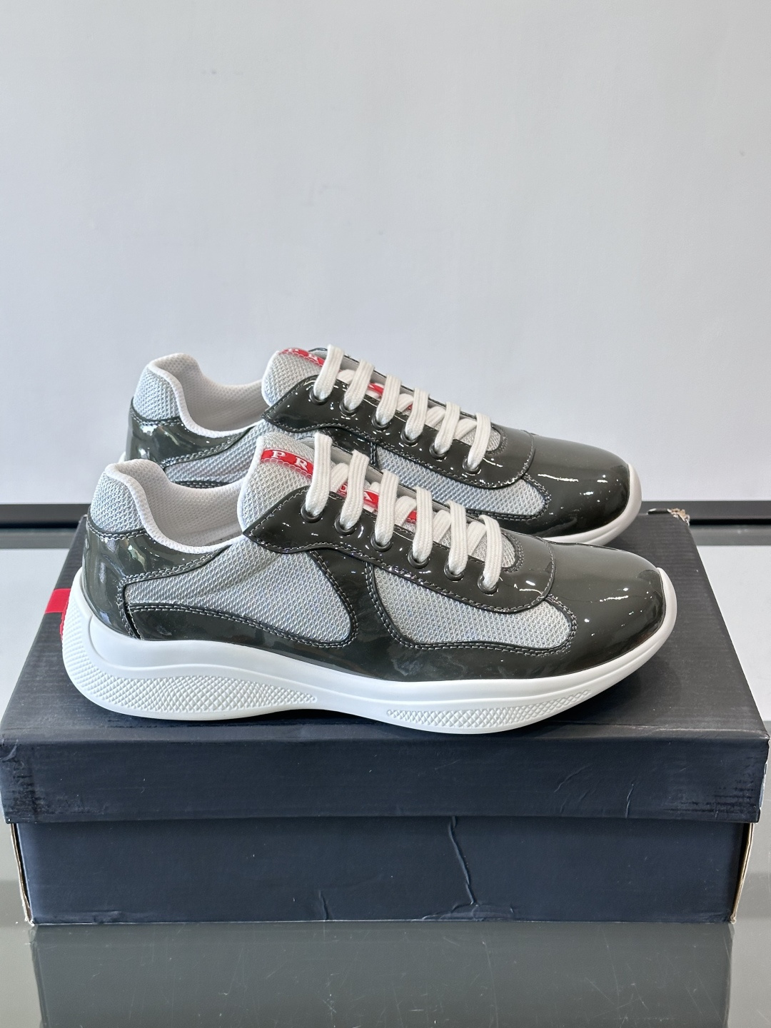 Prada 美洲杯运动鞋​​✨Prada美洲杯系列运动鞋，漆皮+网面拼接，光泽感与透气性兼具。低帮设计，