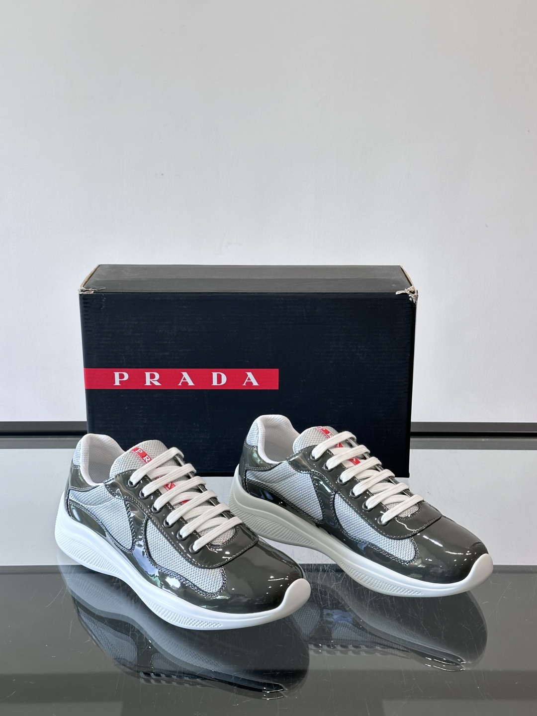Prada 美洲杯运动鞋​​✨Prada美洲杯系列运动鞋，漆皮+网面拼接，光泽感与透气性兼具。低帮设计，