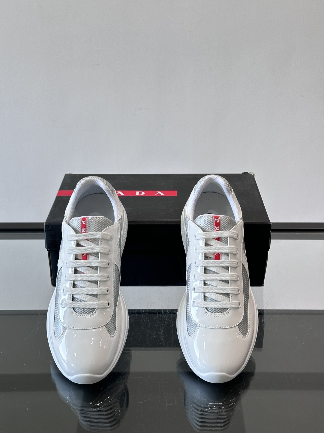 Prada 美洲杯运动鞋​​✨Prada美洲杯系列运动鞋，漆皮+网面拼接，光泽感与透气性兼具。低帮设计，