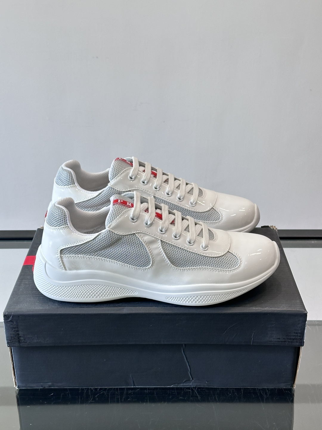 Prada 美洲杯运动鞋​​✨Prada美洲杯系列运动鞋，漆皮+网面拼接，光泽感与透气性兼具。低帮设计，