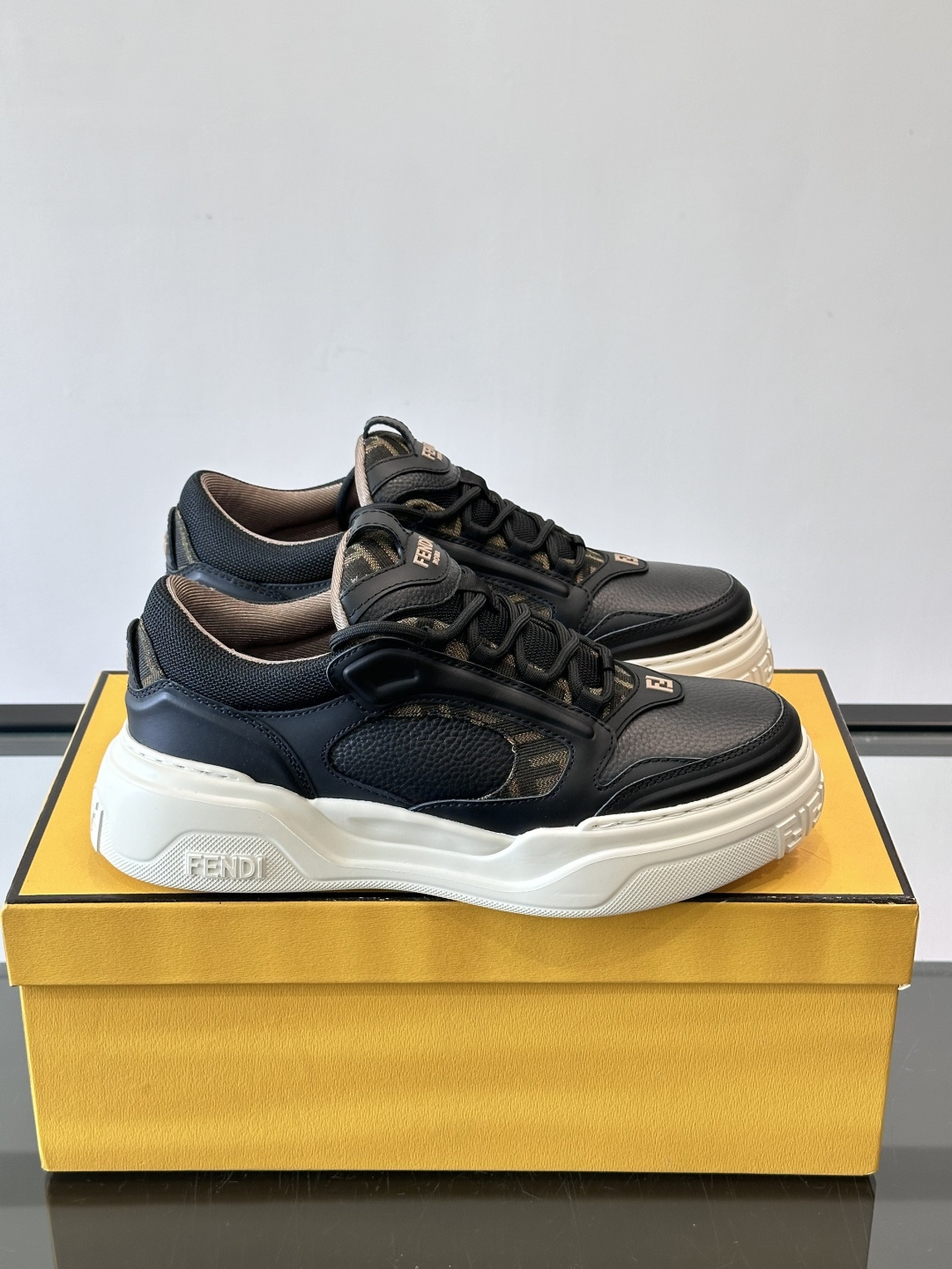 FENDI男士老爹鞋采用深紫、藏蓝与灰色拼接设计，麂皮与网眼材质混搭，厚底白色中底印有品牌Logo，整体