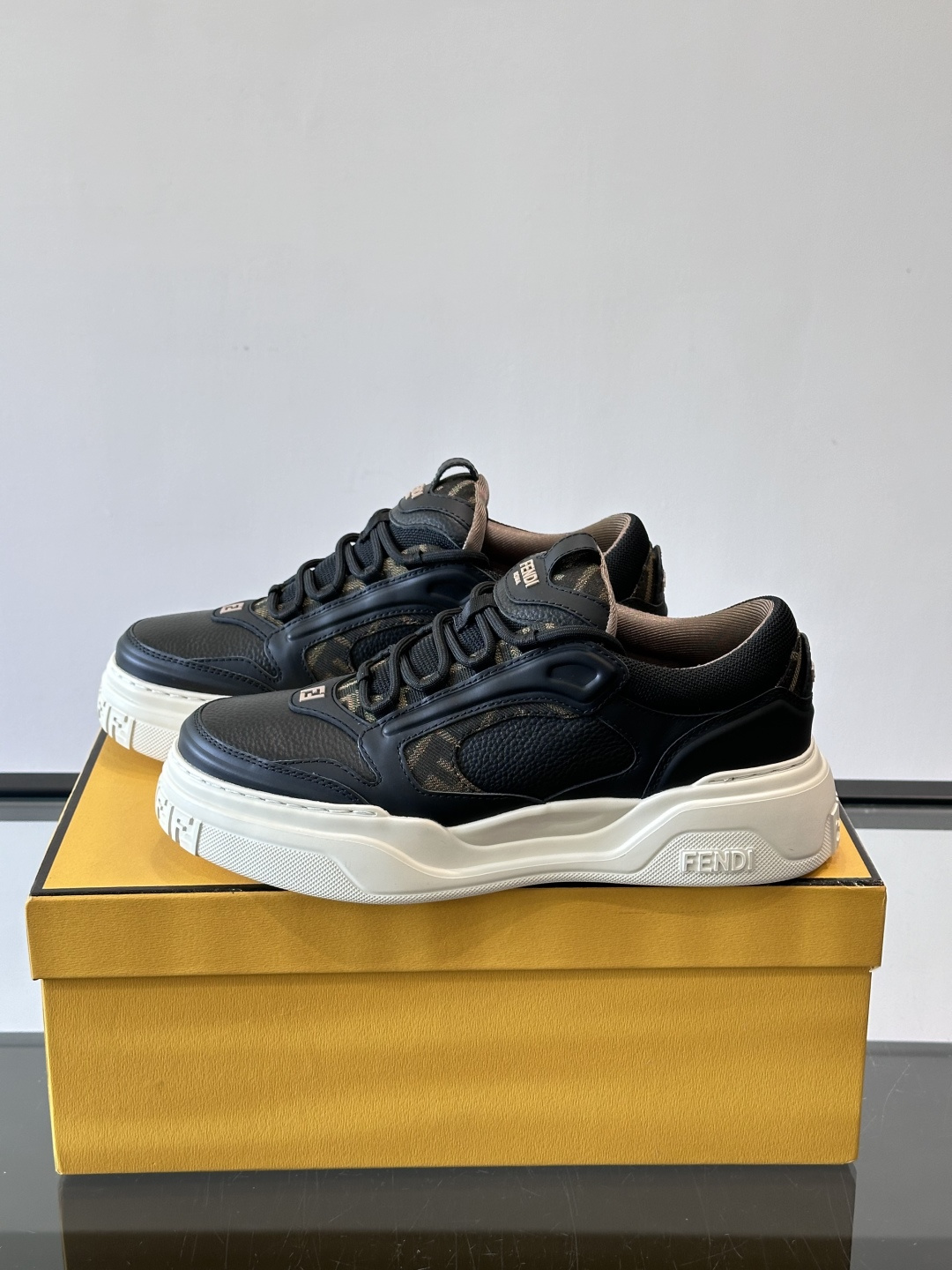 FENDI男士老爹鞋采用深紫、藏蓝与灰色拼接设计，麂皮与网眼材质混搭，厚底白色中底印有品牌Logo，整体