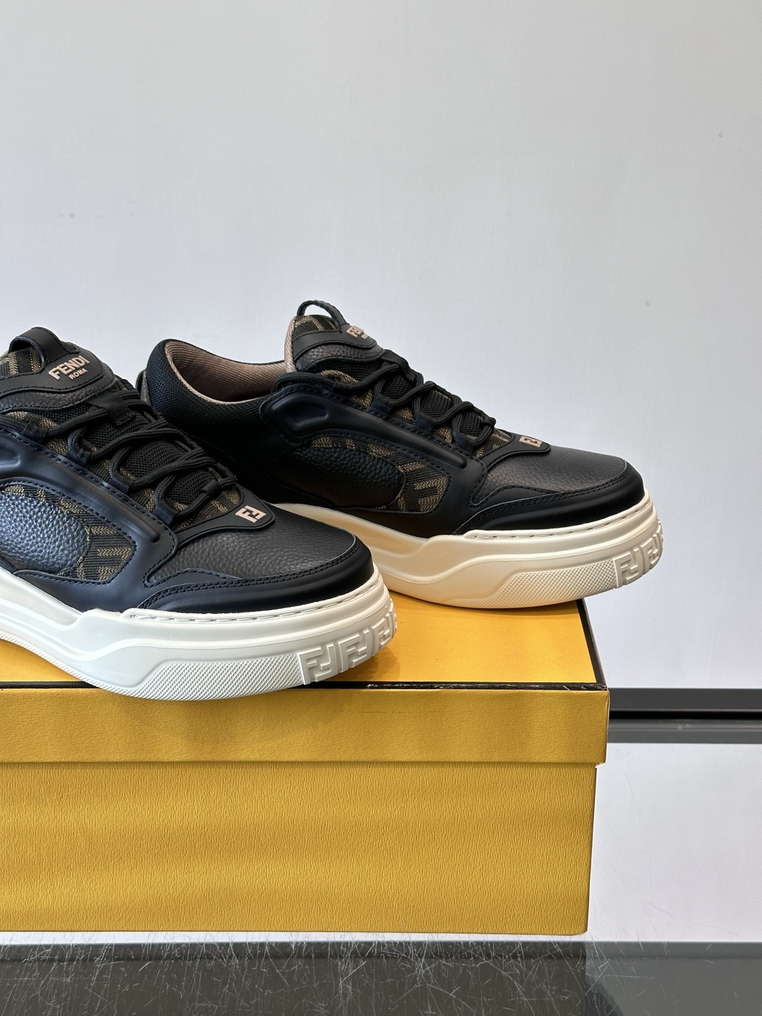 FENDI男士老爹鞋采用深紫、藏蓝与灰色拼接设计，麂皮与网眼材质混搭，厚底白色中底印有品牌Logo，整体