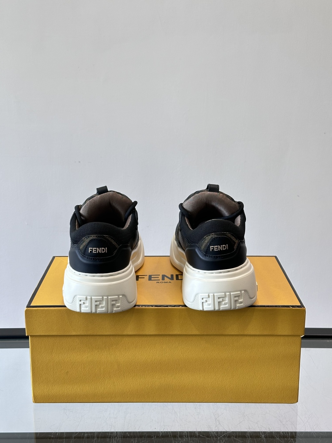 FENDI男士老爹鞋采用深紫、藏蓝与灰色拼接设计，麂皮与网眼材质混搭，厚底白色中底印有品牌Logo，整体