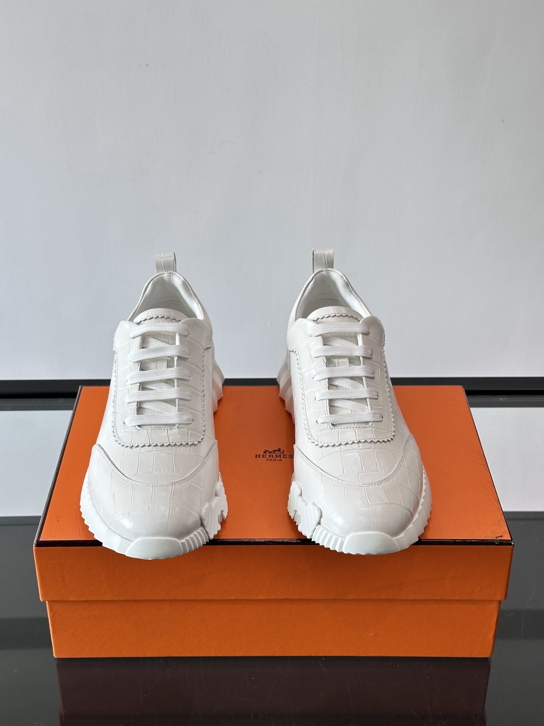 H爱马仕这双鞋是经典的鳄鱼纹运动鞋，鞋面采用仿鳄鱼皮纹理设计，搭配标志性的锯齿状厚底，整体风格兼具奢华感