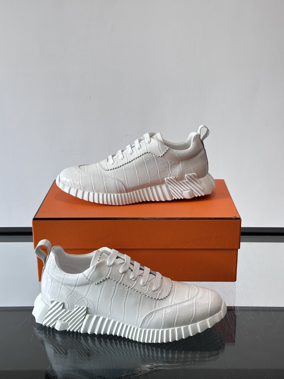H爱马仕这双鞋是经典的鳄鱼纹运动鞋，鞋面采用仿鳄鱼皮纹理设计，搭配标志性的锯齿状厚底，整体风格兼具奢华感