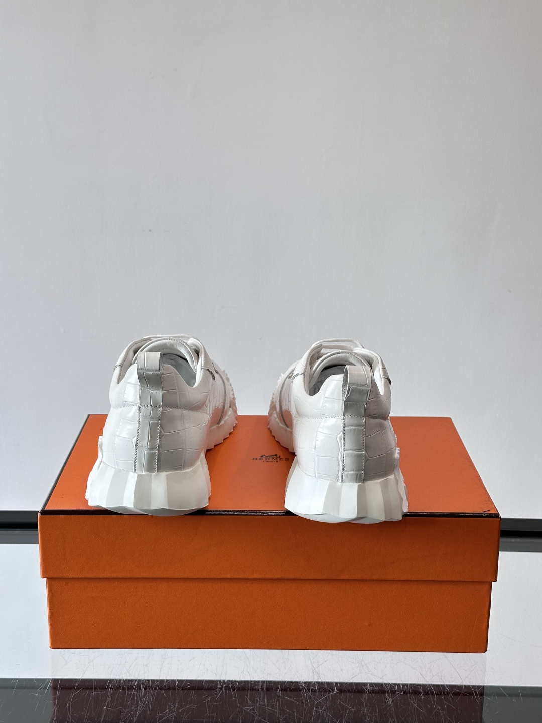 H爱马仕这双鞋是经典的鳄鱼纹运动鞋，鞋面采用仿鳄鱼皮纹理设计，搭配标志性的锯齿状厚底，整体风格兼具奢华感