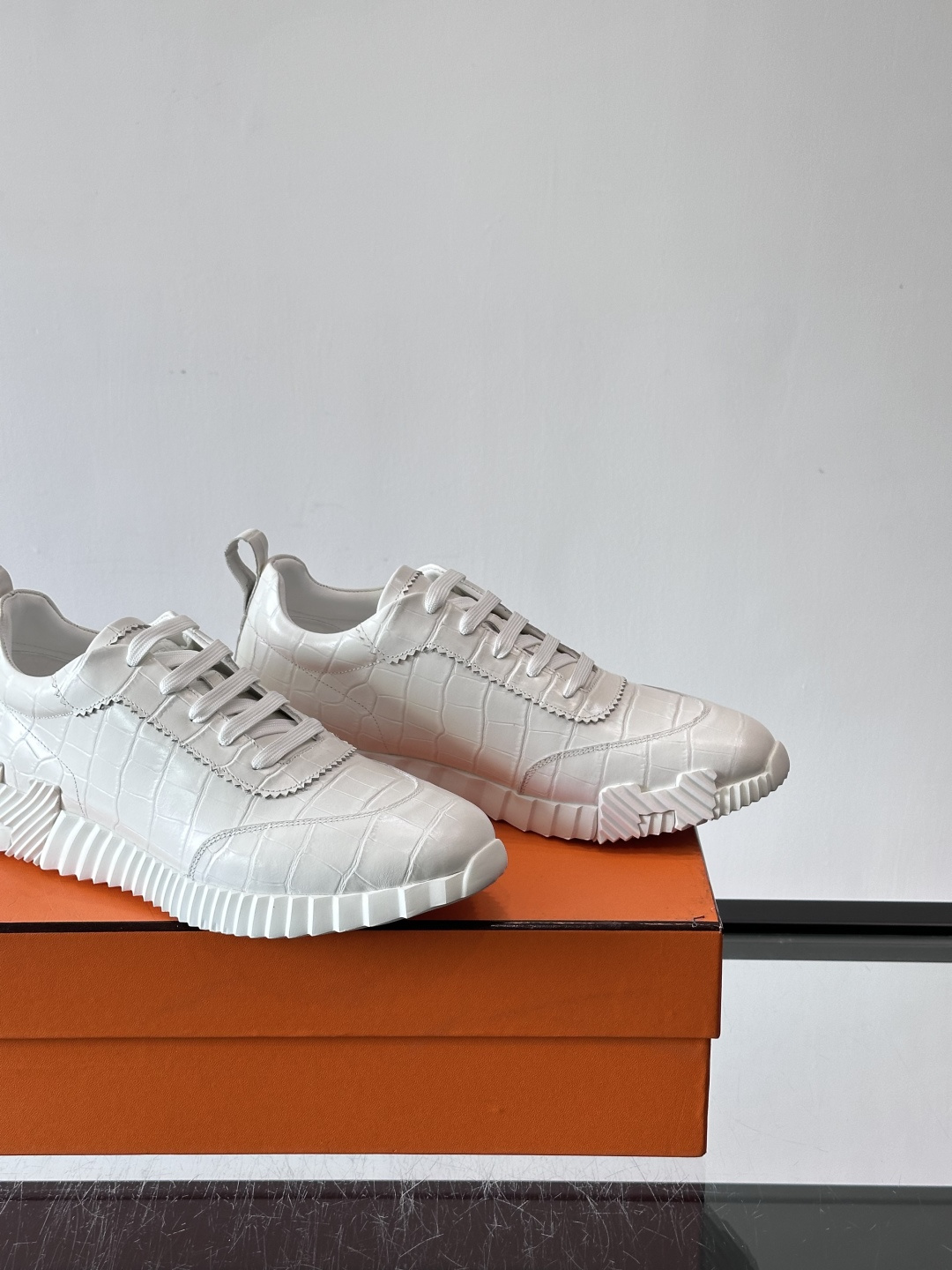 H爱马仕这双鞋是经典的鳄鱼纹运动鞋，鞋面采用仿鳄鱼皮纹理设计，搭配标志性的锯齿状厚底，整体风格兼具奢华感