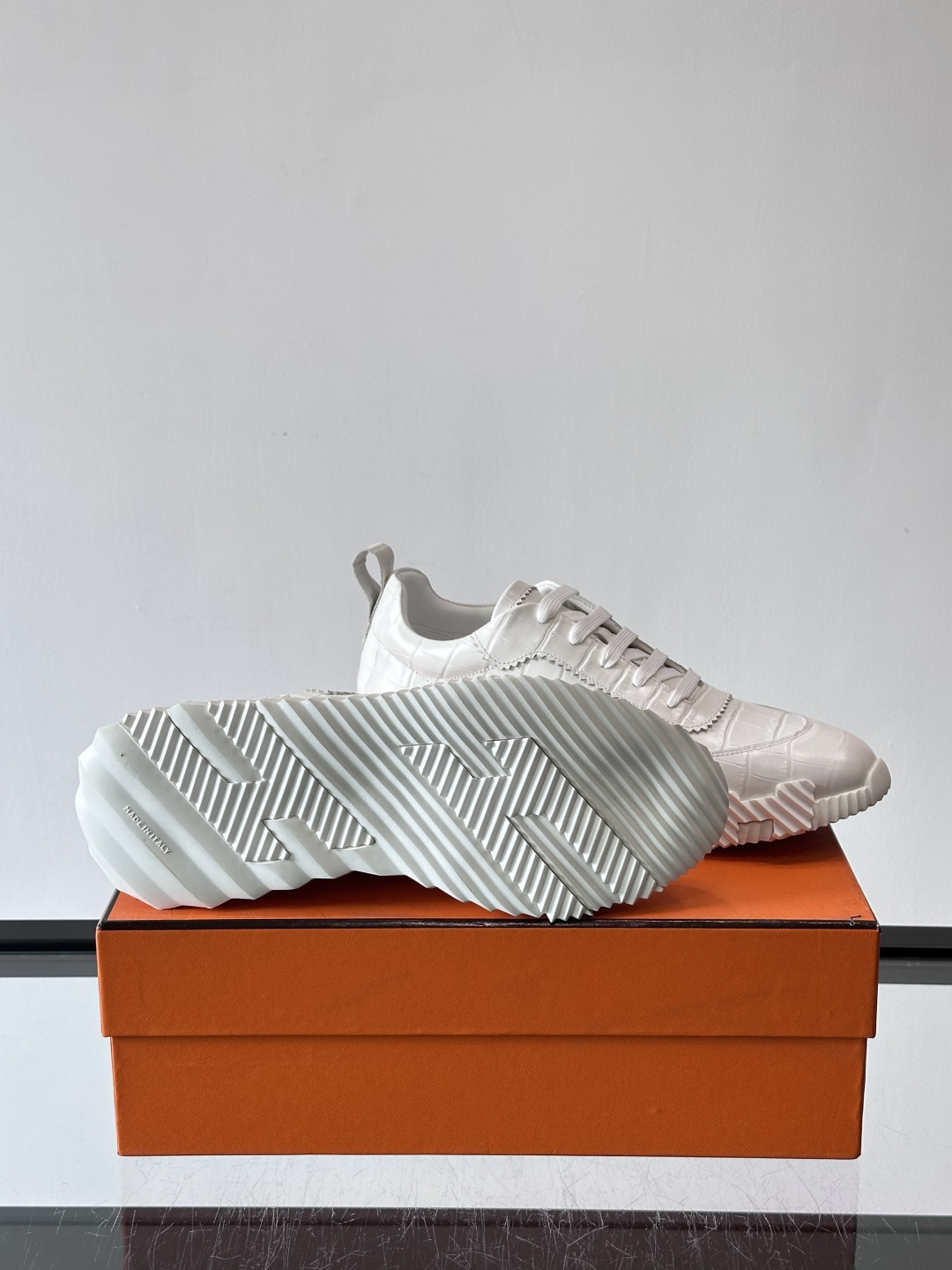 H爱马仕这双鞋是经典的鳄鱼纹运动鞋，鞋面采用仿鳄鱼皮纹理设计，搭配标志性的锯齿状厚底，整体风格兼具奢华感