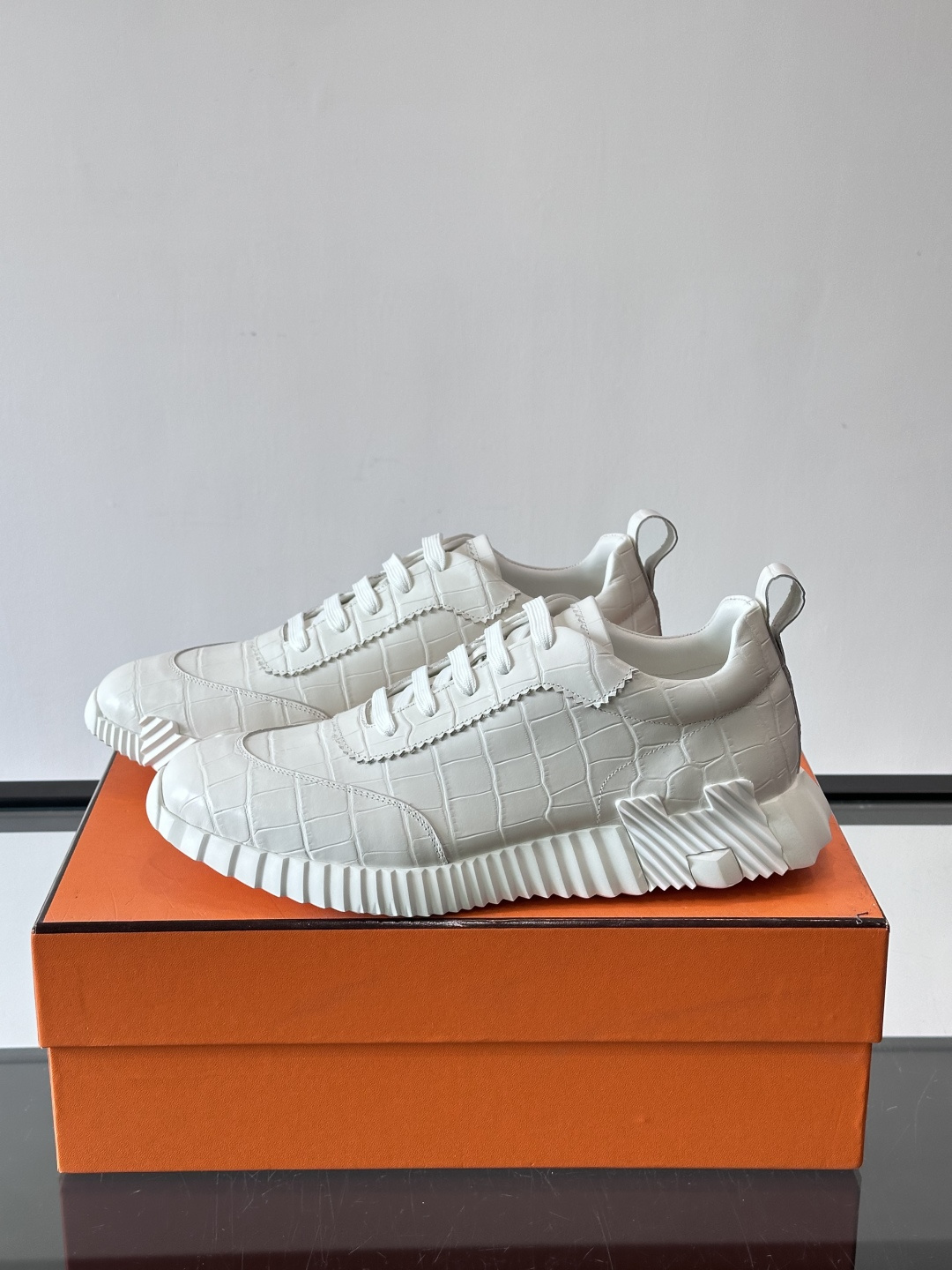 H爱马仕这双鞋是经典的鳄鱼纹运动鞋，鞋面采用仿鳄鱼皮纹理设计，搭配标志性的锯齿状厚底，整体风格兼具奢华感