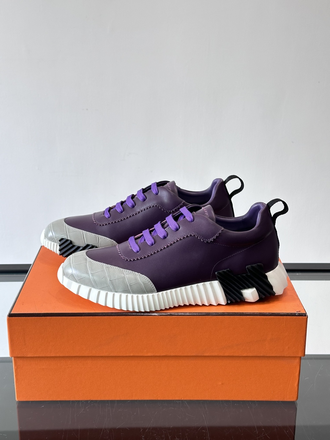 H爱马仕这双鞋是经典的鳄鱼纹运动鞋，鞋面采用仿鳄鱼皮纹理设计，搭配标志性的锯齿状厚底，整体风格兼具奢华感