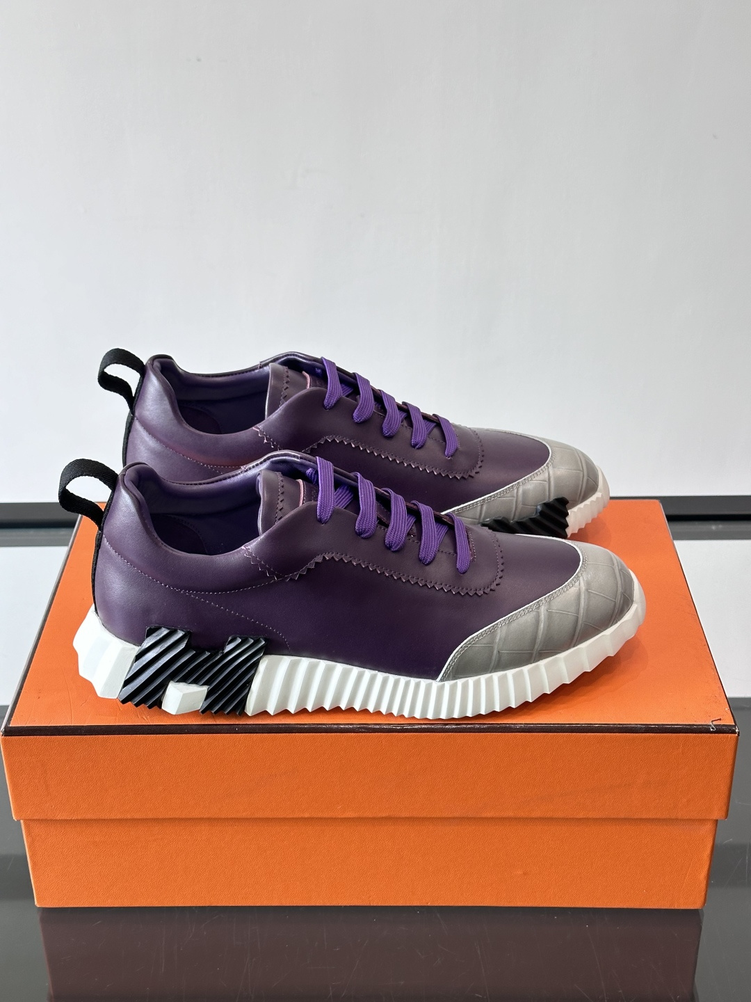 H爱马仕这双鞋是经典的鳄鱼纹运动鞋，鞋面采用仿鳄鱼皮纹理设计，搭配标志性的锯齿状厚底，整体风格兼具奢华感