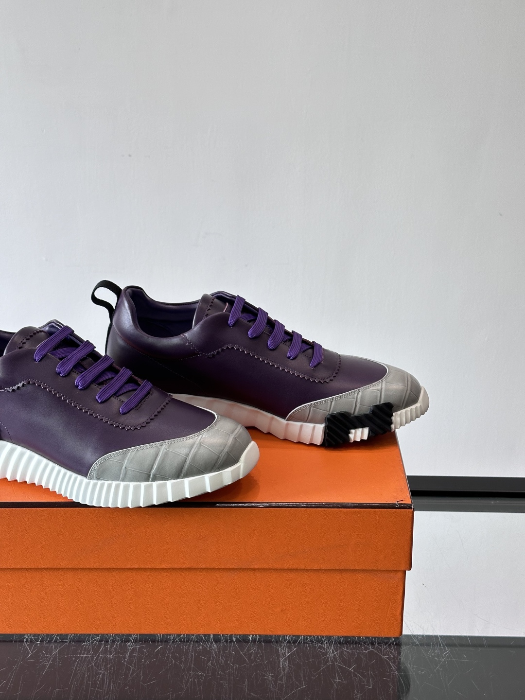 H爱马仕这双鞋是经典的鳄鱼纹运动鞋，鞋面采用仿鳄鱼皮纹理设计，搭配标志性的锯齿状厚底，整体风格兼具奢华感