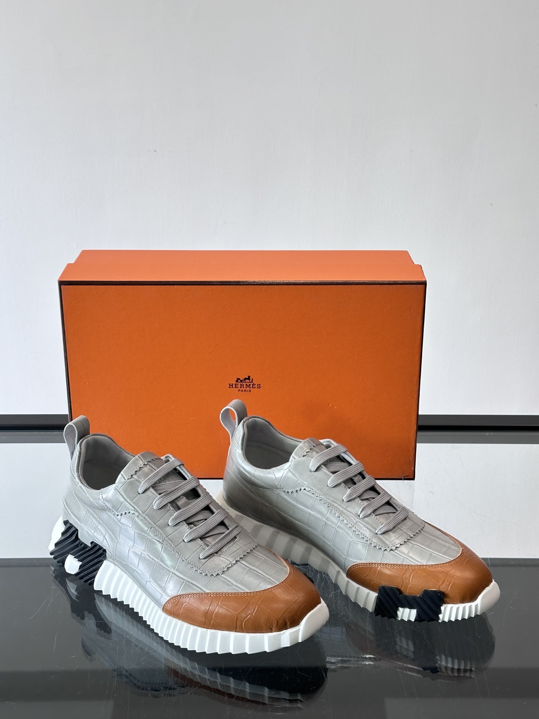 H爱马仕这双鞋是经典的鳄鱼纹运动鞋，鞋面采用仿鳄鱼皮纹理设计，搭配标志性的锯齿状厚底，整体风格兼具奢华感