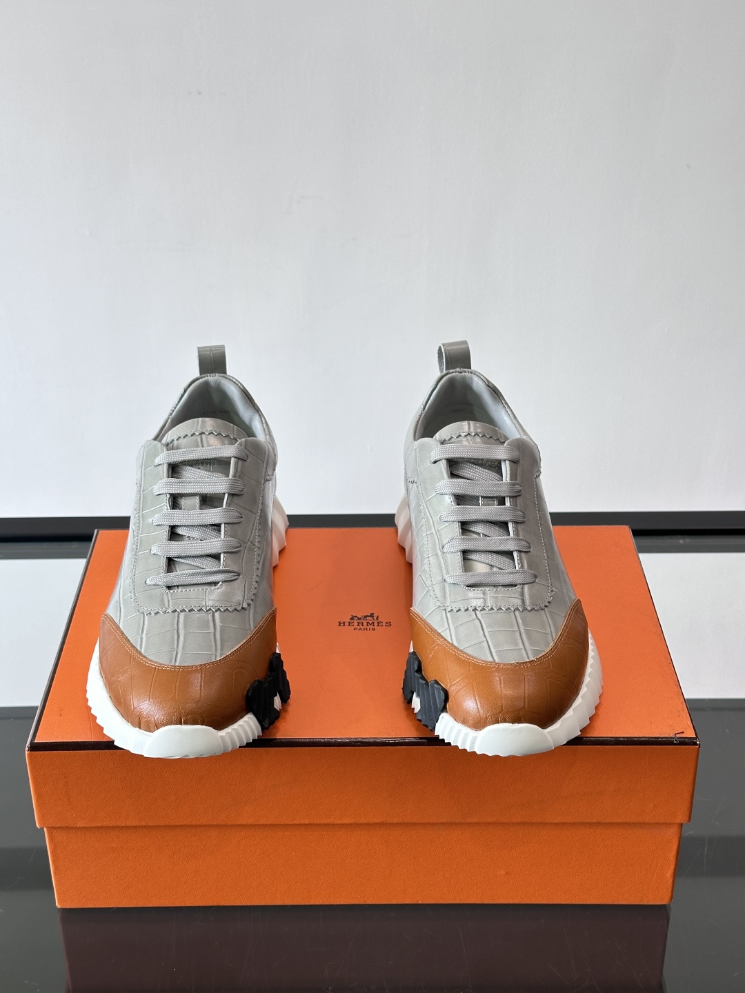 H爱马仕这双鞋是经典的鳄鱼纹运动鞋，鞋面采用仿鳄鱼皮纹理设计，搭配标志性的锯齿状厚底，整体风格兼具奢华感