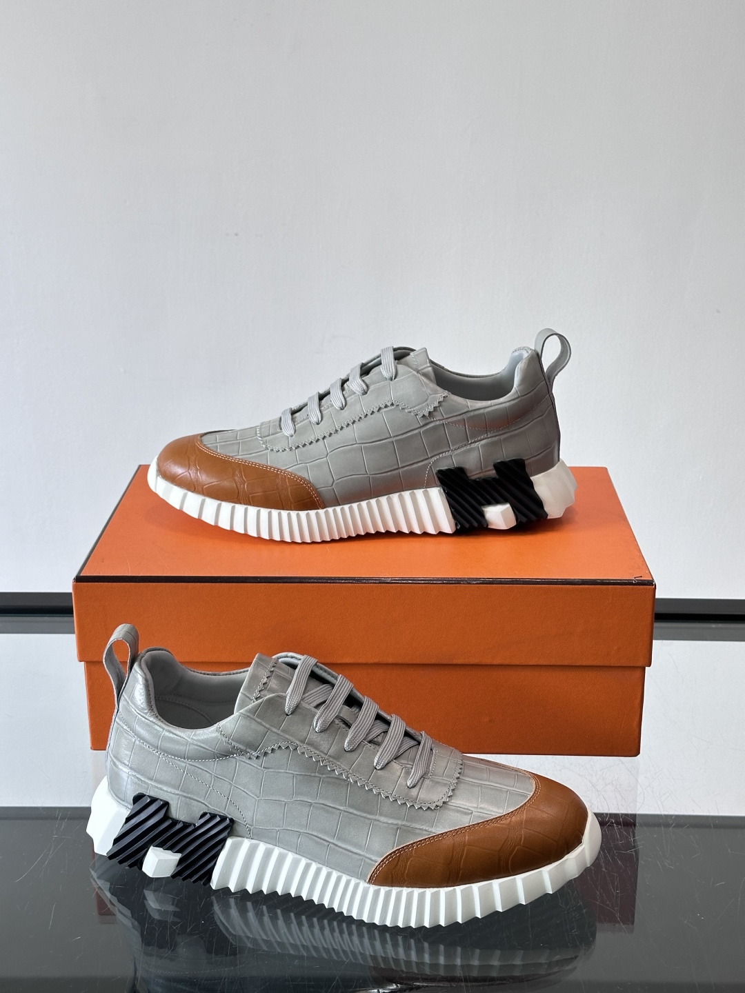 H爱马仕这双鞋是经典的鳄鱼纹运动鞋，鞋面采用仿鳄鱼皮纹理设计，搭配标志性的锯齿状厚底，整体风格兼具奢华感