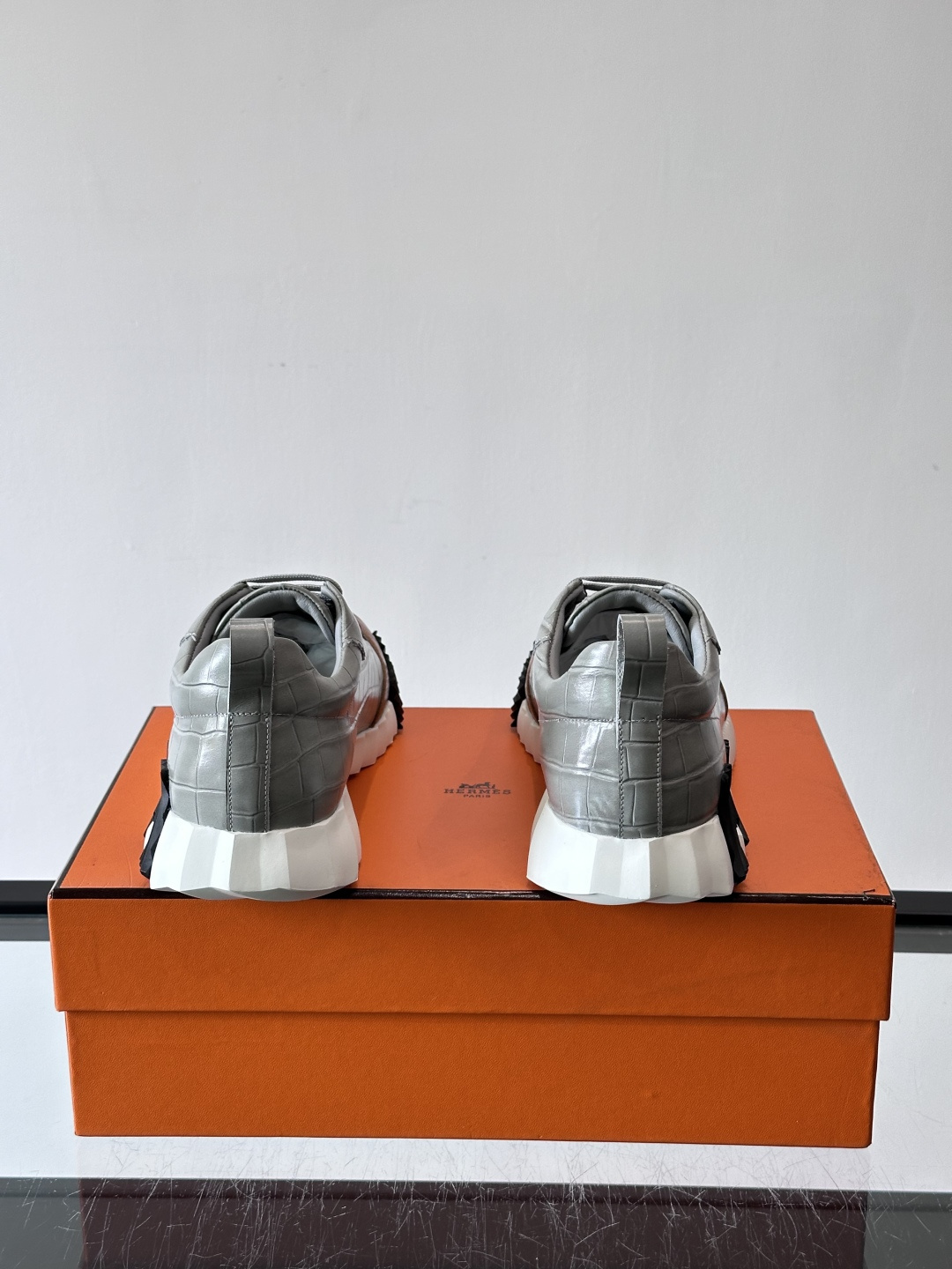 H爱马仕这双鞋是经典的鳄鱼纹运动鞋，鞋面采用仿鳄鱼皮纹理设计，搭配标志性的锯齿状厚底，整体风格兼具奢华感