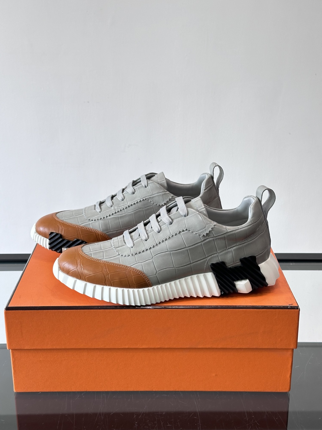 H爱马仕这双鞋是经典的鳄鱼纹运动鞋，鞋面采用仿鳄鱼皮纹理设计，搭配标志性的锯齿状厚底，整体风格兼具奢华感