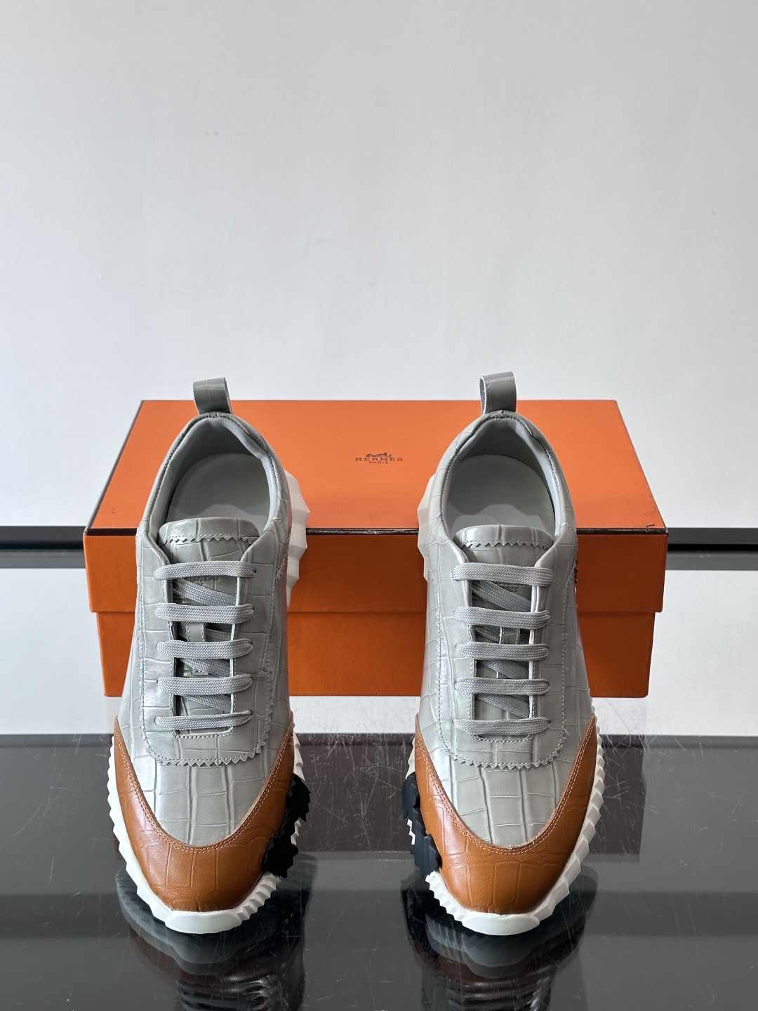 H爱马仕这双鞋是经典的鳄鱼纹运动鞋，鞋面采用仿鳄鱼皮纹理设计，搭配标志性的锯齿状厚底，整体风格兼具奢华感