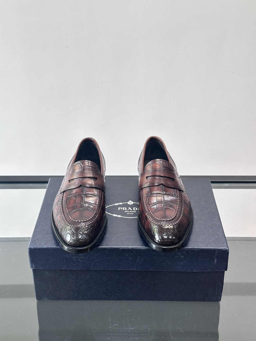 Prada男士复古皮鞋采用优质皮革打造，鞋头处精致的设计，搭配经典的皮质搭扣，整体风格优雅又不失细节感。