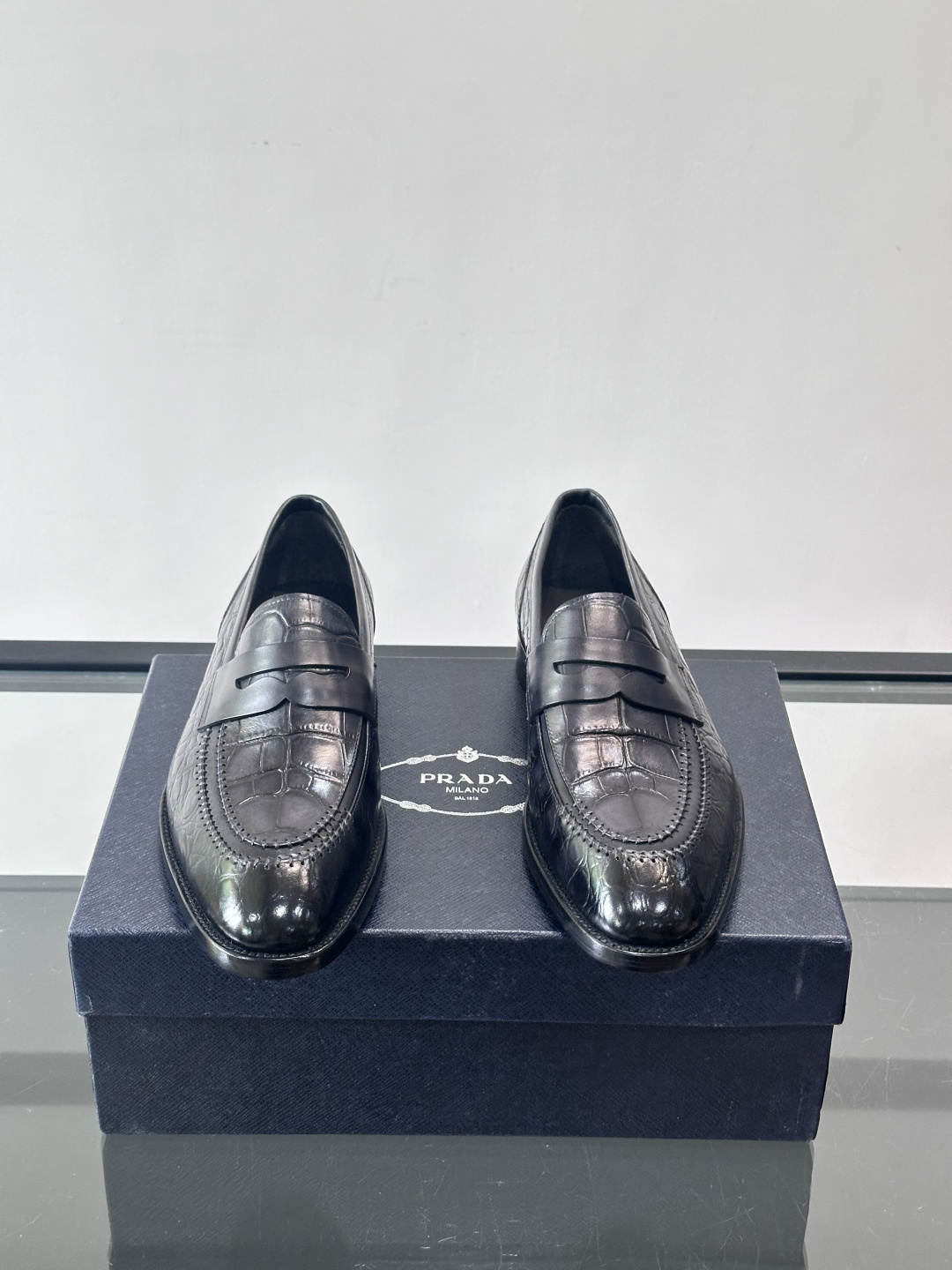 Prada男士复古皮鞋采用优质皮革打造，鞋头处精致的设计，搭配经典的皮质搭扣，整体风格优雅又不失细节感。