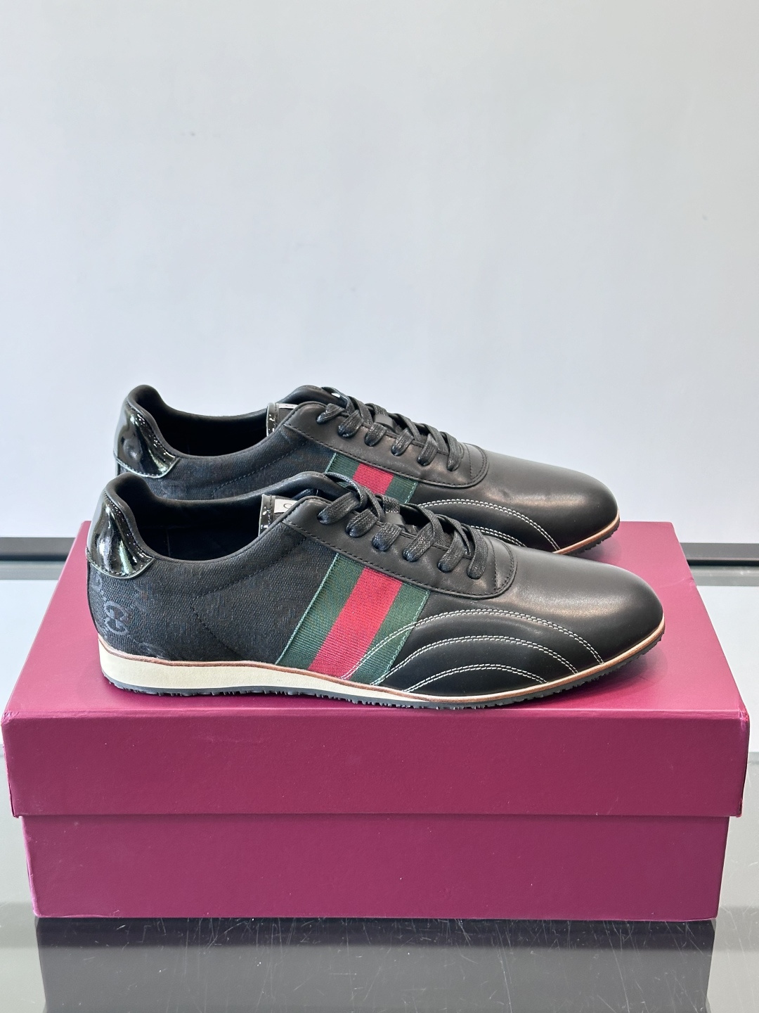 Gucci经典的复古运动鞋，采用皮革与GG老花帆布拼接设计，侧面饰有品牌标志性的红绿织带，鞋型圆润复古，