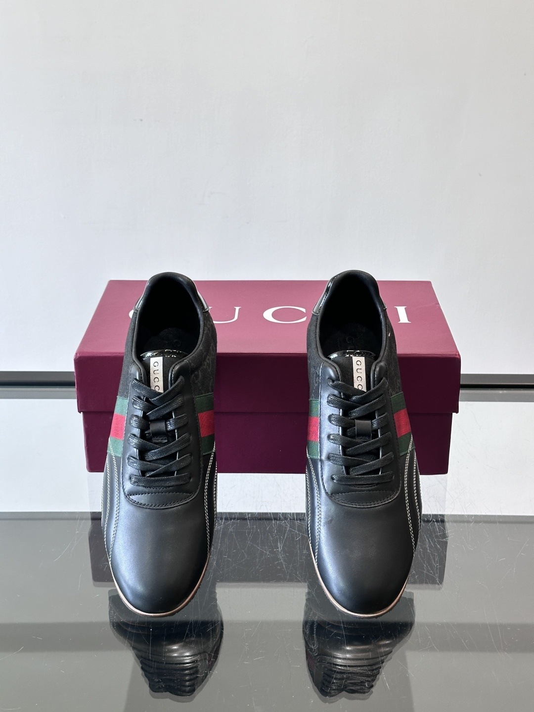 Gucci经典的复古运动鞋，采用皮革与GG老花帆布拼接设计，侧面饰有品牌标志性的红绿织带，鞋型圆润复古，