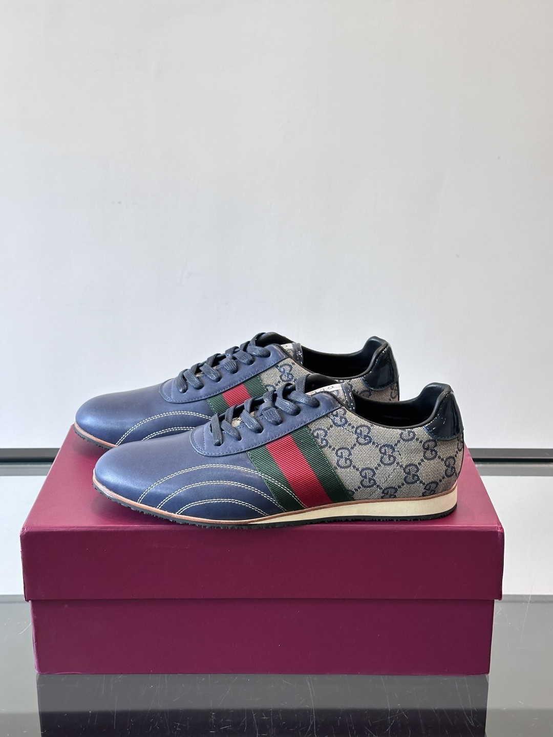 Gucci经典的复古运动鞋，采用皮革与GG老花帆布拼接设计，侧面饰有品牌标志性的红绿织带，鞋型圆润复古，
