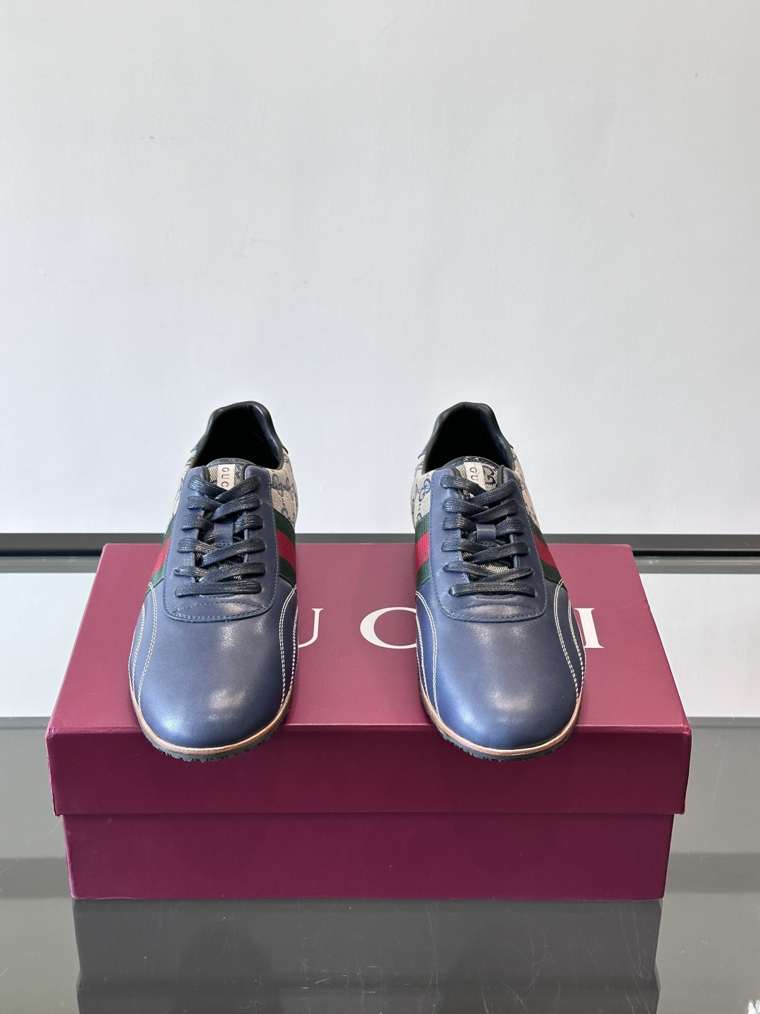 Gucci经典的复古运动鞋，采用皮革与GG老花帆布拼接设计，侧面饰有品牌标志性的红绿织带，鞋型圆润复古，