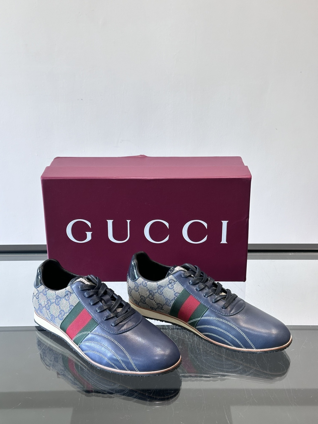 Gucci经典的复古运动鞋，采用皮革与GG老花帆布拼接设计，侧面饰有品牌标志性的红绿织带，鞋型圆润复古，